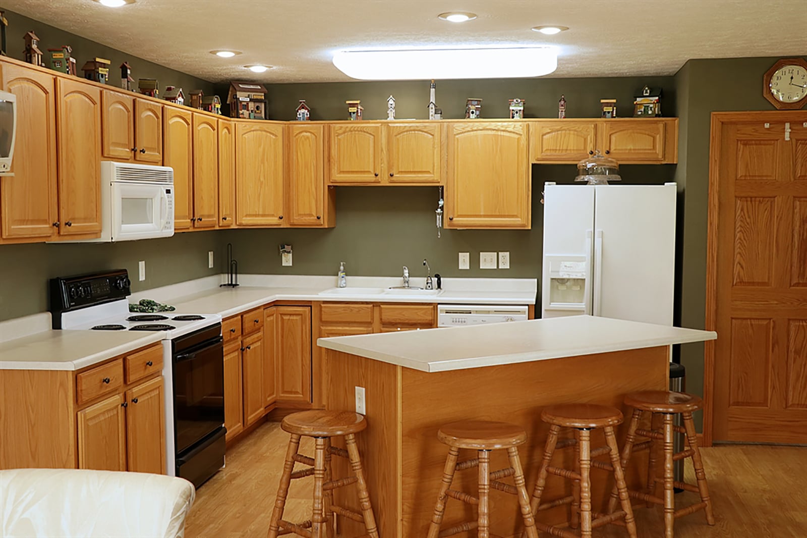 The kitchen has two walls of oak cabinetry and complementing light countertops. There is a double sink and additional outlets for media hook-ups. There is a pantry closet and an island that has additional storage and breakfast bar seating for up to four. CONTRIBUTED PHOTO BY KATHY TYLER