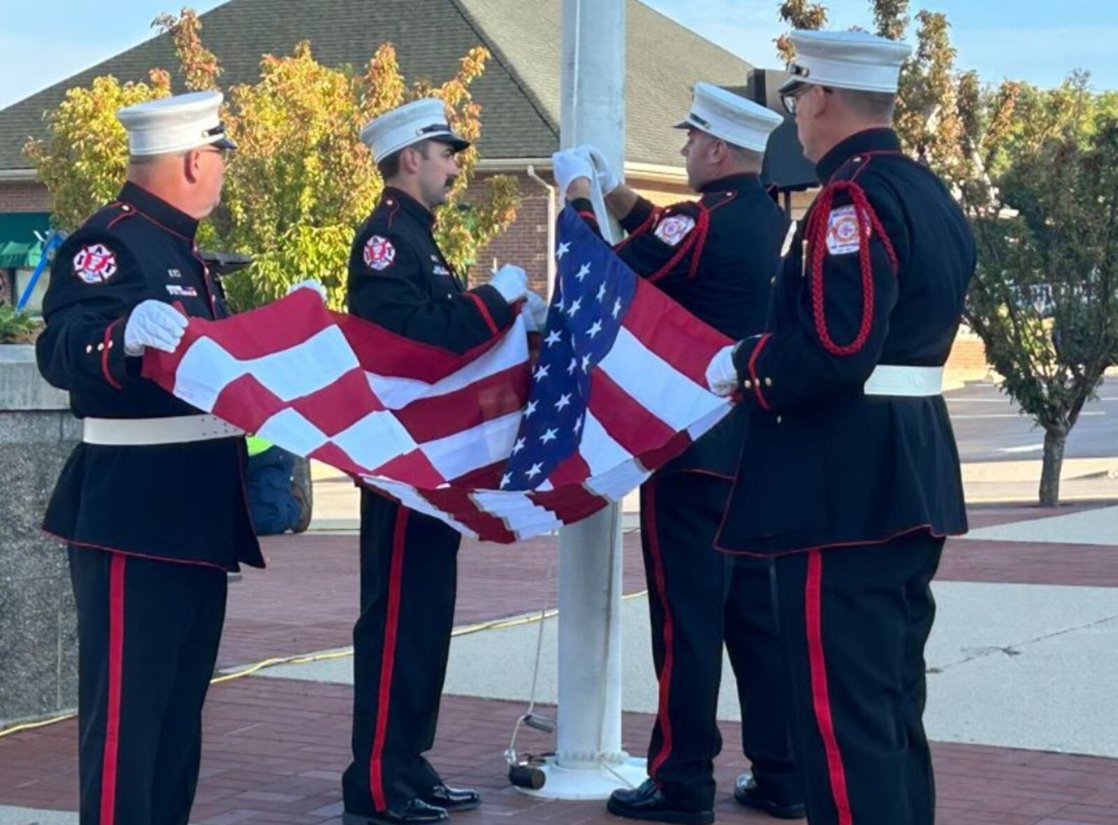 Four members of the Monroe Fire Department honor guard, from left, firefighters David Hayes and Dan Lietz, Lt. Aaron Forrer and Assistant Chief Matt Grubbs install the new American flag Monday morning outside the City Building. RICK McCRABB/STAFF