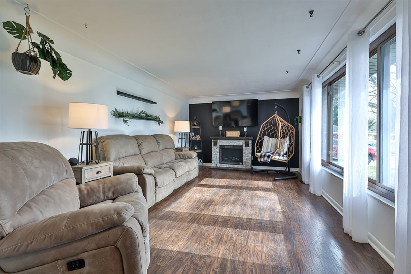 A picture window fills the living room with natural light and an electric stone fireplace provides some warmth.