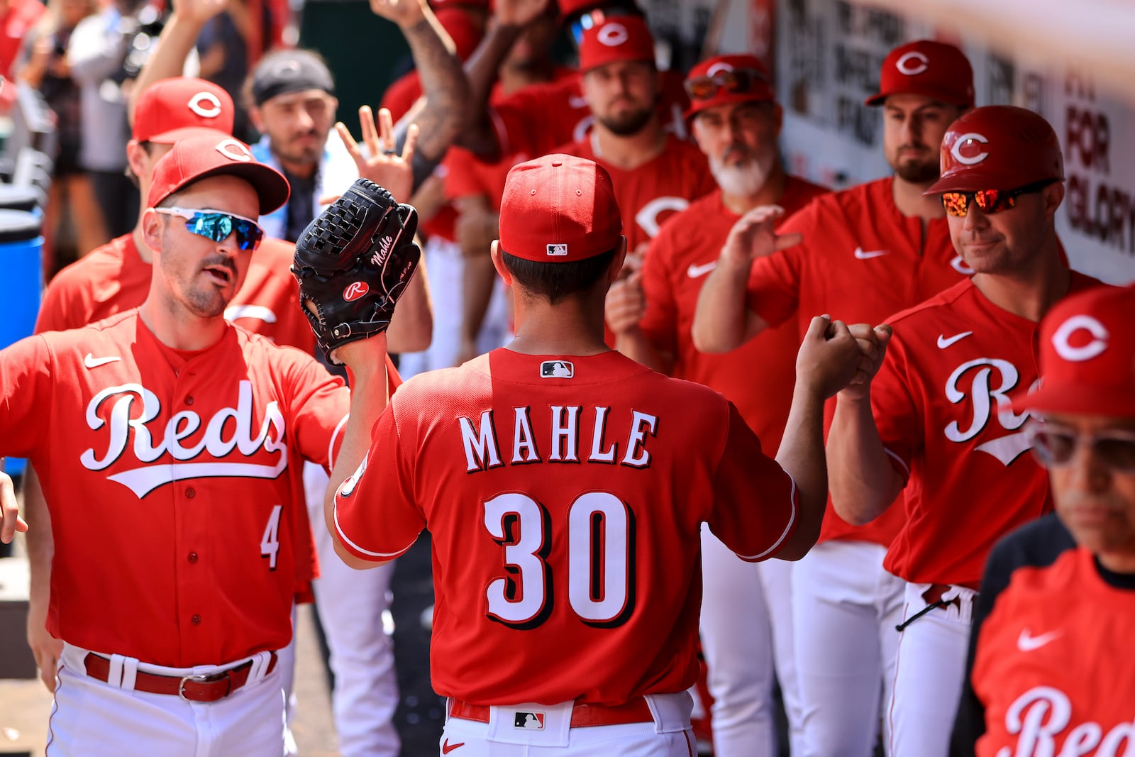 Cincinnati Reds' Tyler Mahle (30) high-fives teammates in the dugout after being pulled during the seventh inning of a baseball game against the San Francisco Giants in Cincinnati, Sunday, May 29, 2022. (AP Photo/Aaron Doster)