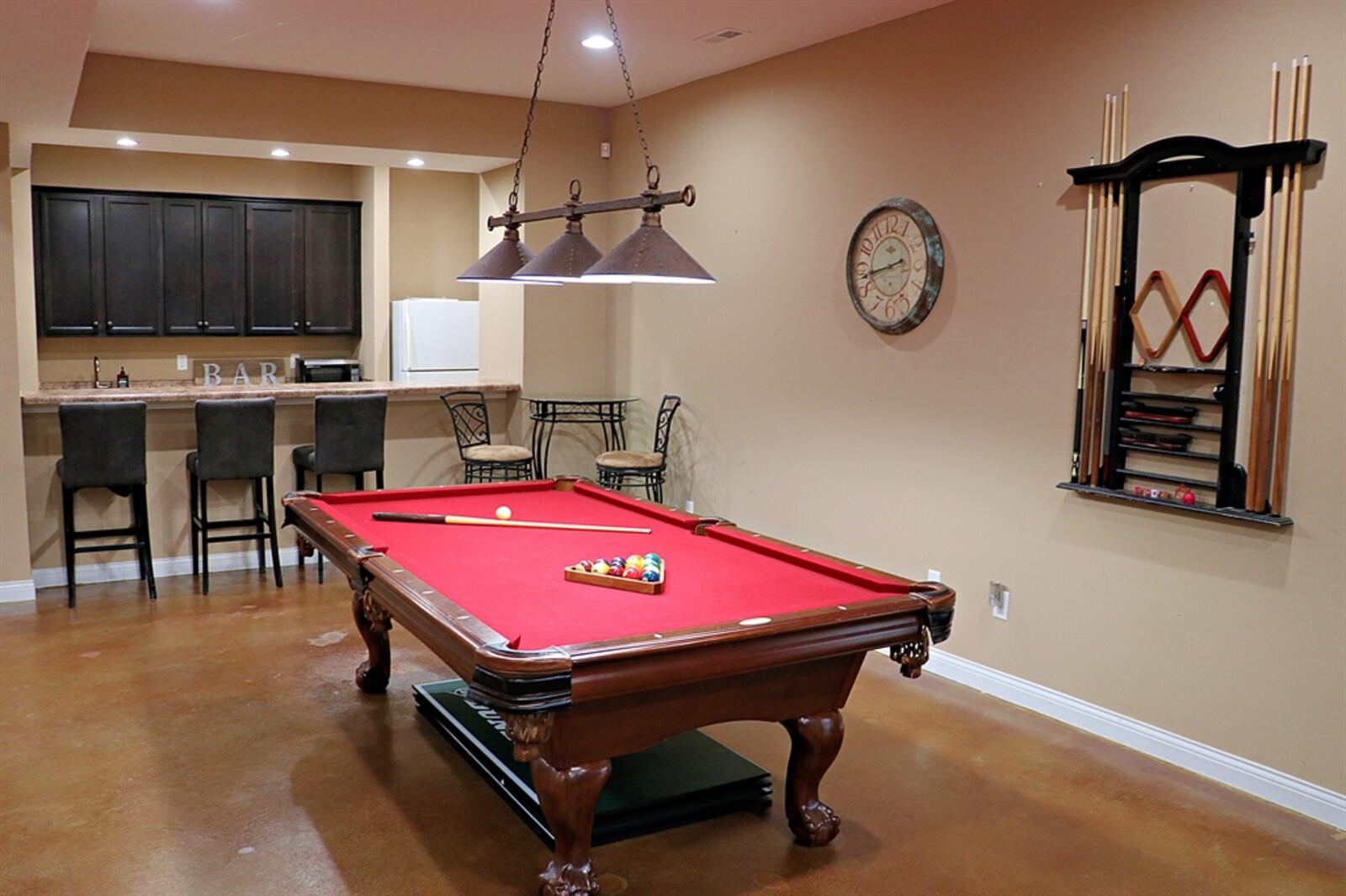 The open staircase wraps down to the walk-out basement, which has been finished into a recreation room, media room and wet bar area. 