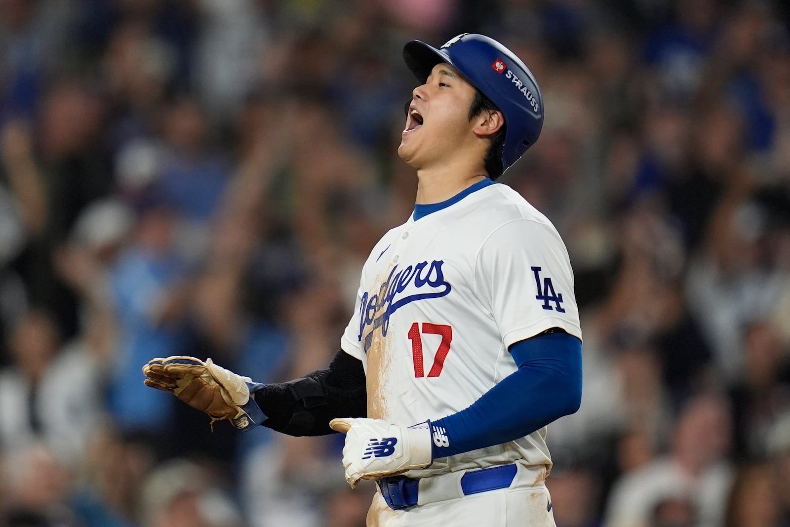 Los Angeles Dodgers' Shohei Ohtani celebrates after scoring on a double by Mookie Betts during the eighth inning in Game 1 of a baseball NL Championship Series against the New York Mets, Sunday, Oct. 13, 2024, in Los Angeles. (AP Photo/Gregory Bull)