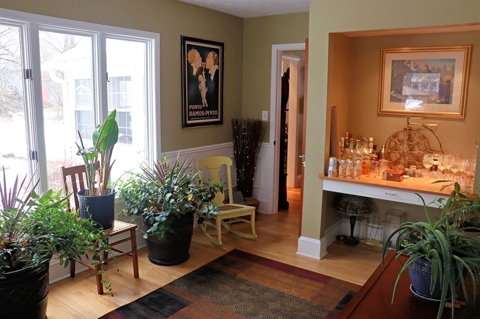 Closer to the great room is a beverage station with a beverage cooler, microwave and bubble-glass-panel cabinetry.