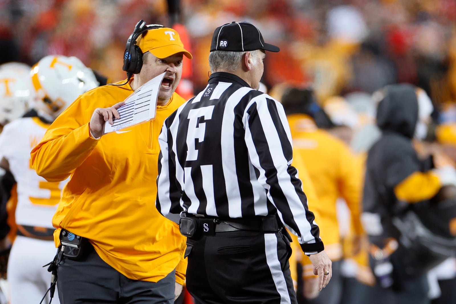 Tennessee head coach Josh Heupel, left, argues with a referee, right, during the first half in the first round of the College Football Playoff against Ohio State, Saturday, Dec. 21, 2024, in Columbus, Ohio. (AP Photo/Jay LaPrete)