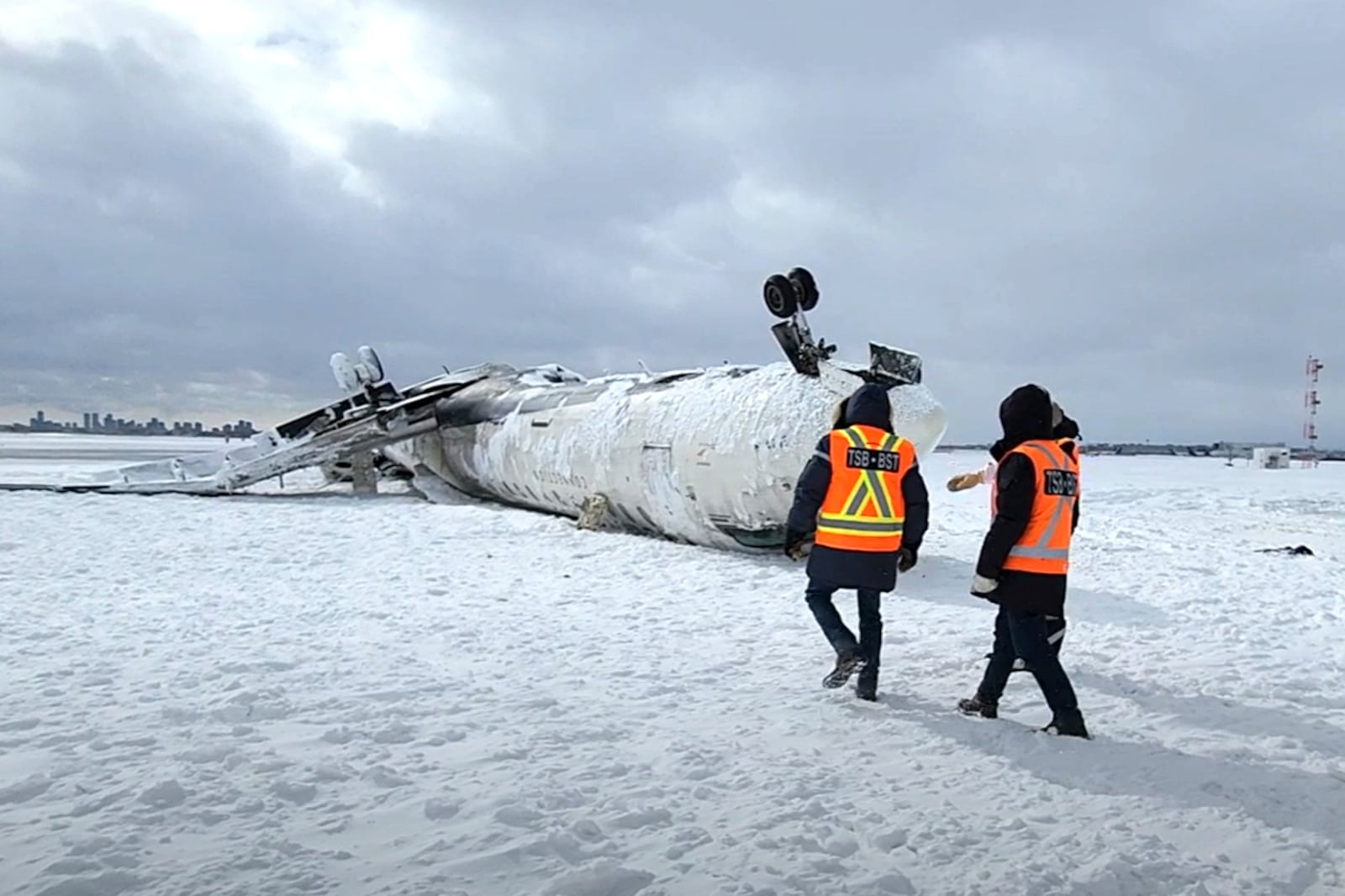 In this image provided by the National Transportation Safety Board, investigators examine the wreckage of a Delta Air Lines jet, Wednesday, Feb. 19, 2025, that burst into flames and flipped upside down as it tried to land on Feb. 17, at Toronto Pearson International Airport in Mississauga, Ontario. (National Transportation Safety Board via AP)