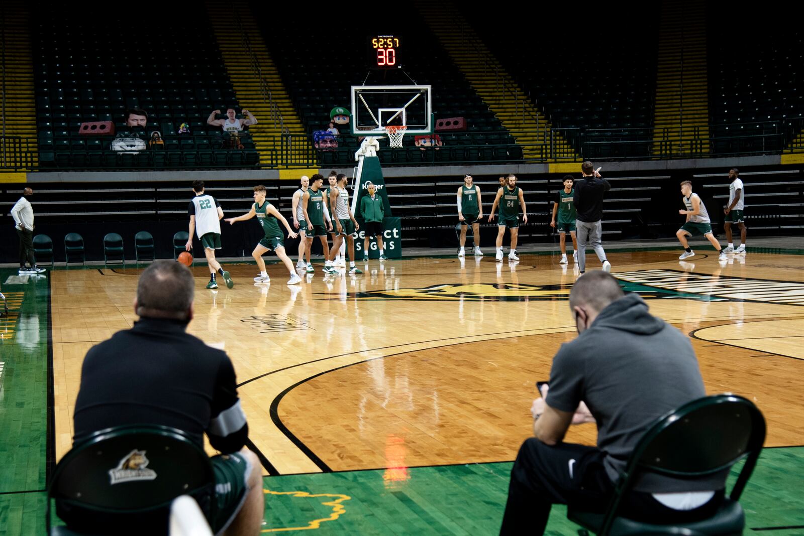 Wright State athletic trainer Jason Franklin (left) and strength and conditiong coordinator Cole Pittsford look on during Friday's practice at the Nutter Center. CONTRIBUTED