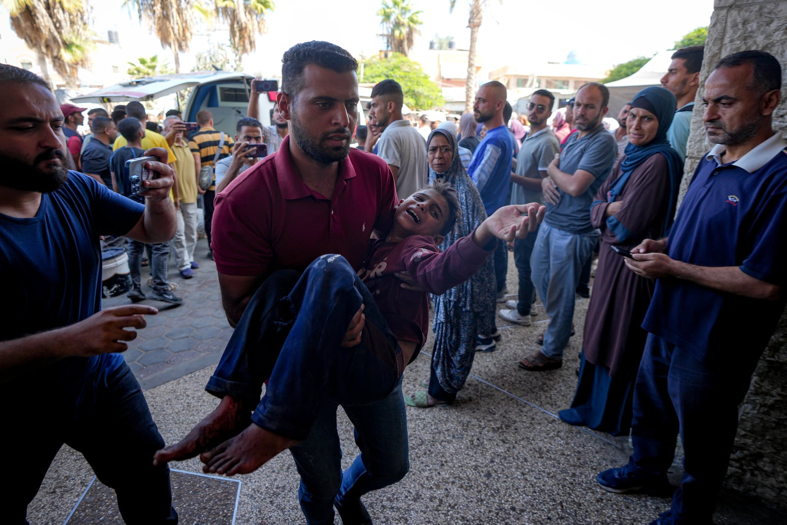 A Palestinian man carries an injured child after an Israeli airstrike in Deir al Balah, Gaza Strip, Thursday, Oct. 10, 2024. (AP Photo/Abdel Kareem Hana)