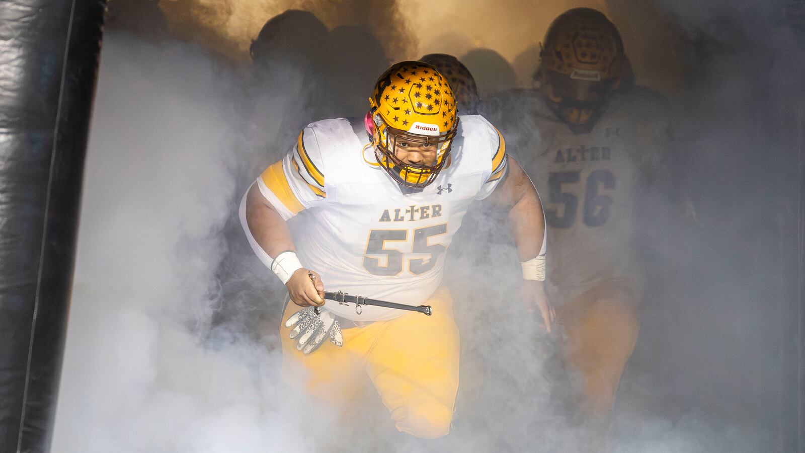 Alter High School senior Jackson Wright runs through the tunnel before the Division IV state championship game against Cleveland Glenville on Saturday night at Tom Benson Hall of Fame Stadium in Canton. CONTRIBUTED PHOTO BY MICHAEL COOPER