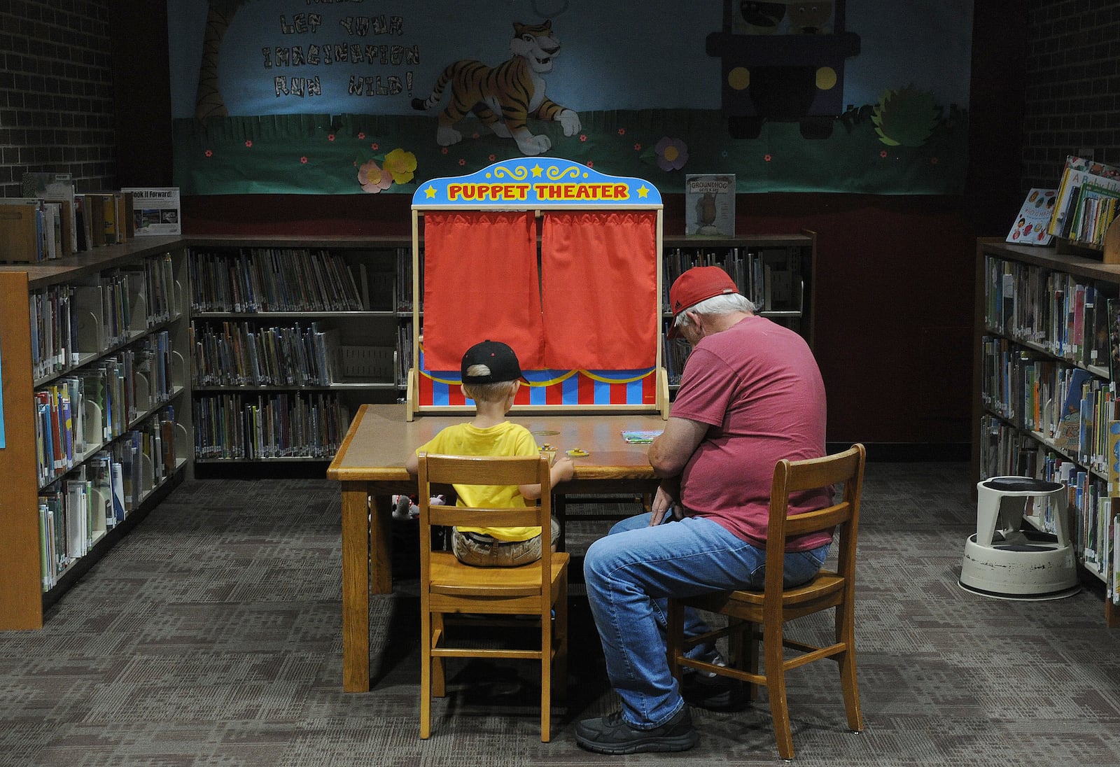 Bill Call and his grandson Zayne, 3, work on a puzzle together at the Troy-Miami County Public Library Thursday July 1, 2021. MARSHALL GORBY\STAFF