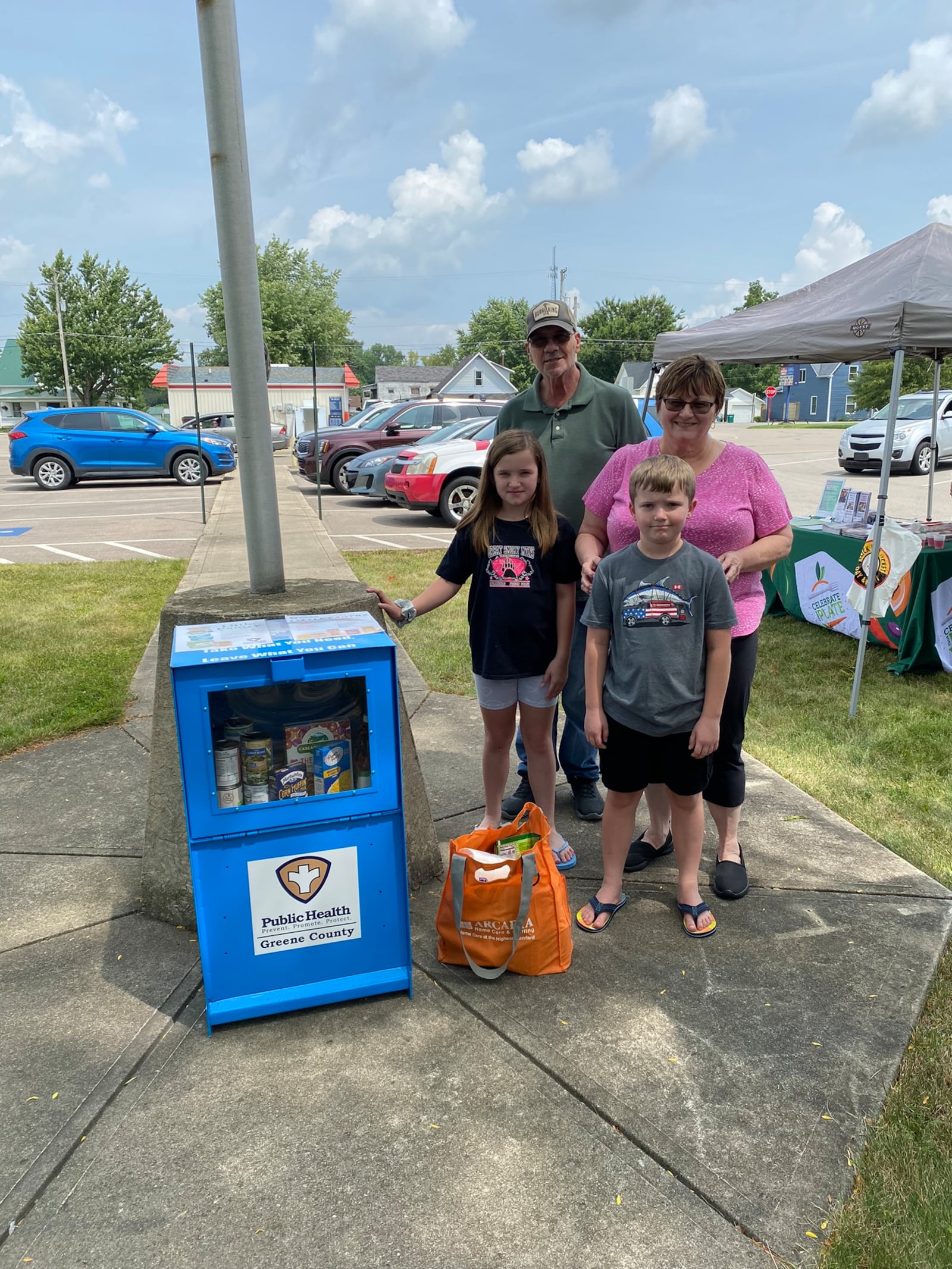 A family provides donations at the Jamestown Community Library little pantry unveiling. CONTRIBUTED