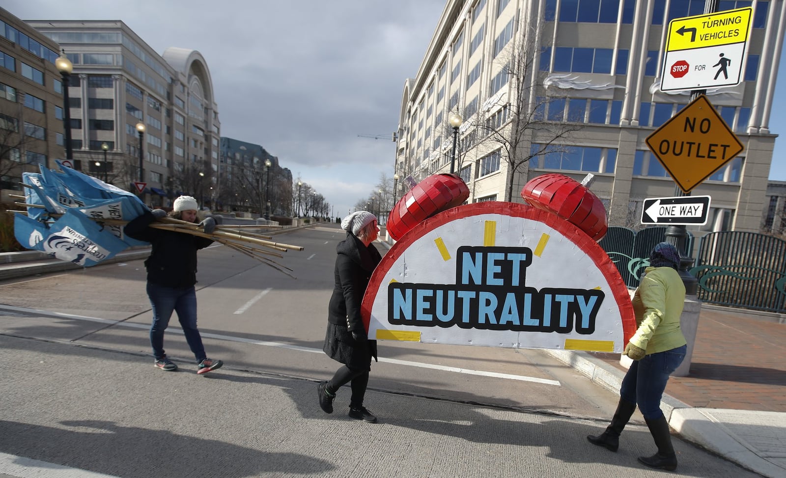 Sammi LeMaster, second from left, and Katherine Fuchs, right, carry the top of an alarm clock display that reads “Net Neutrality” down 12th Street SW to their truck after a protest at the Federal Communications Commission (FCC) in Washington, Thursday, Dec. 14, 2017. The FCC voted to eliminate net-neutrality protections for the internet. (AP Photo/Carolyn Kaster)