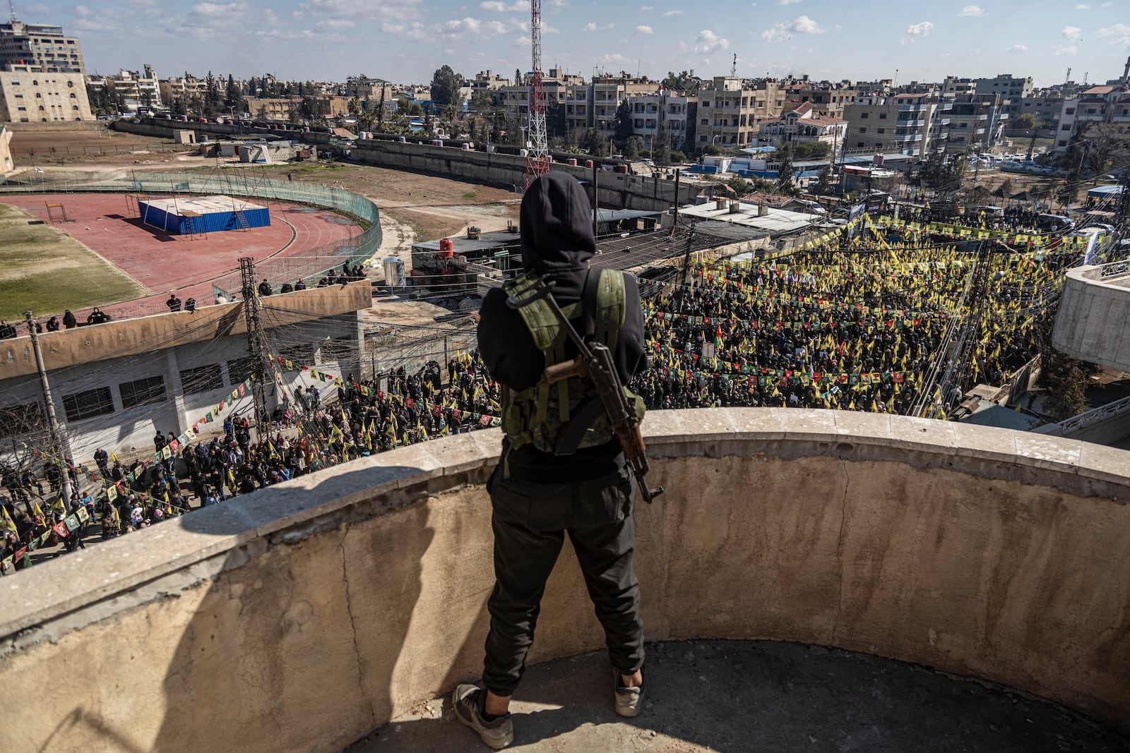 A Syrian Democratic Forces (SDF) fighter watches as hundreds of demonstrators march to demand the release of Kurdish leader Abdullah Ocalan in Qamishli, northeastern Syria, Saturday Feb. 15, 2025.(AP Photo/Baderkhan Ahmad)