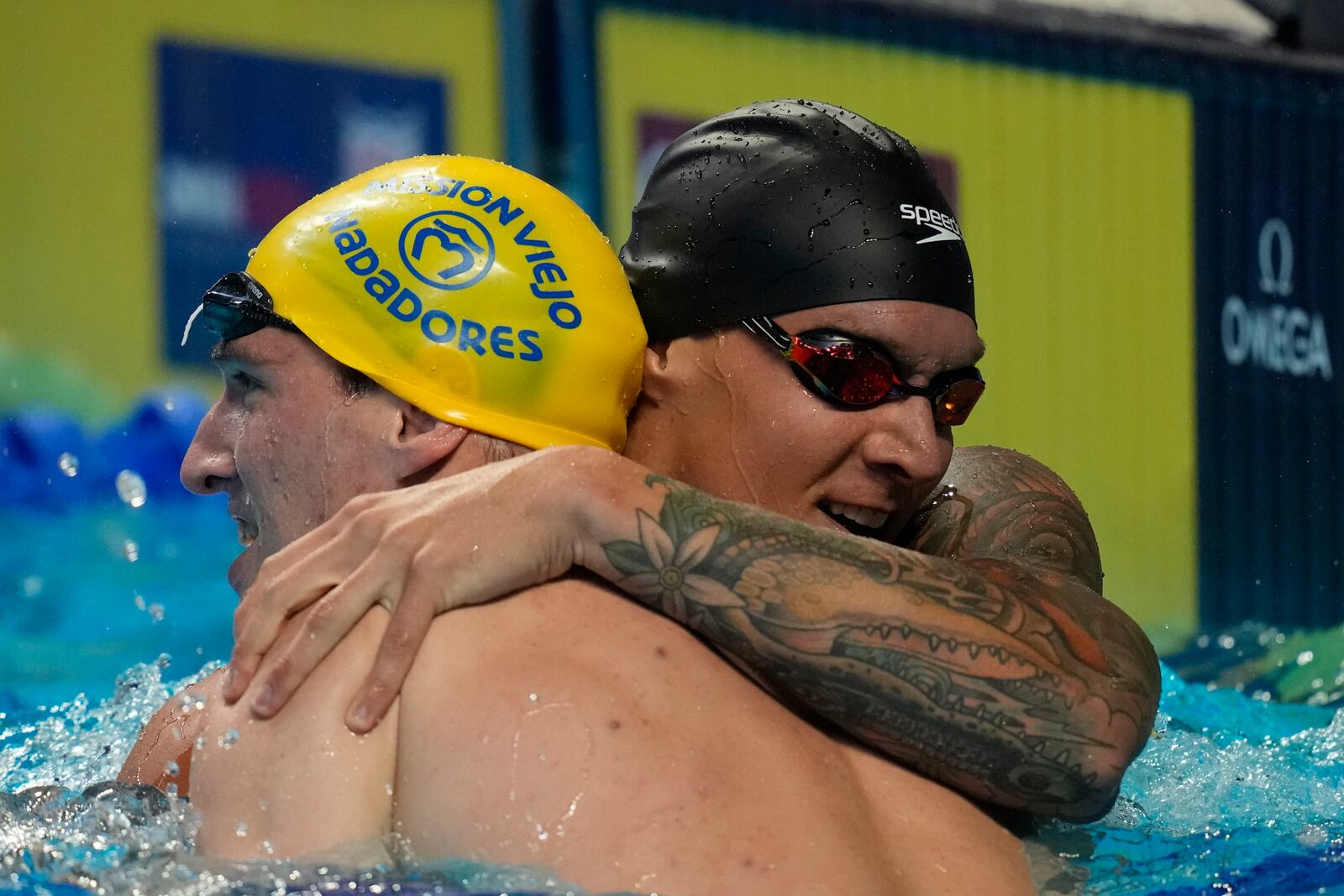 Caeleb Dressel hugs Zach Apple after winning the men's 100 freestyle during wave 2 of the U.S. Olympic Swim Trials on Thursday, June 17, 2021, in Omaha, Neb. (AP Photo/Charlie Neibergall)