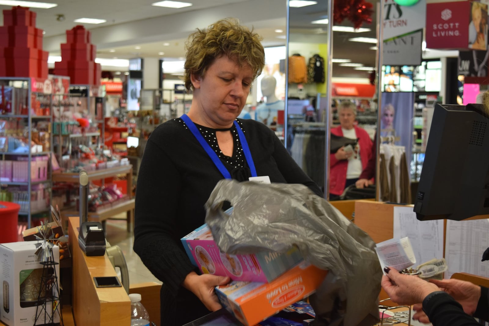 Holiday shoppers are already hitting store as the “Super Bowl” retail week approaches. Tammy Hemmerle bags gifts at the Centerville Kohl’s. STAFF PHOTO / HOLLY SHIVELY