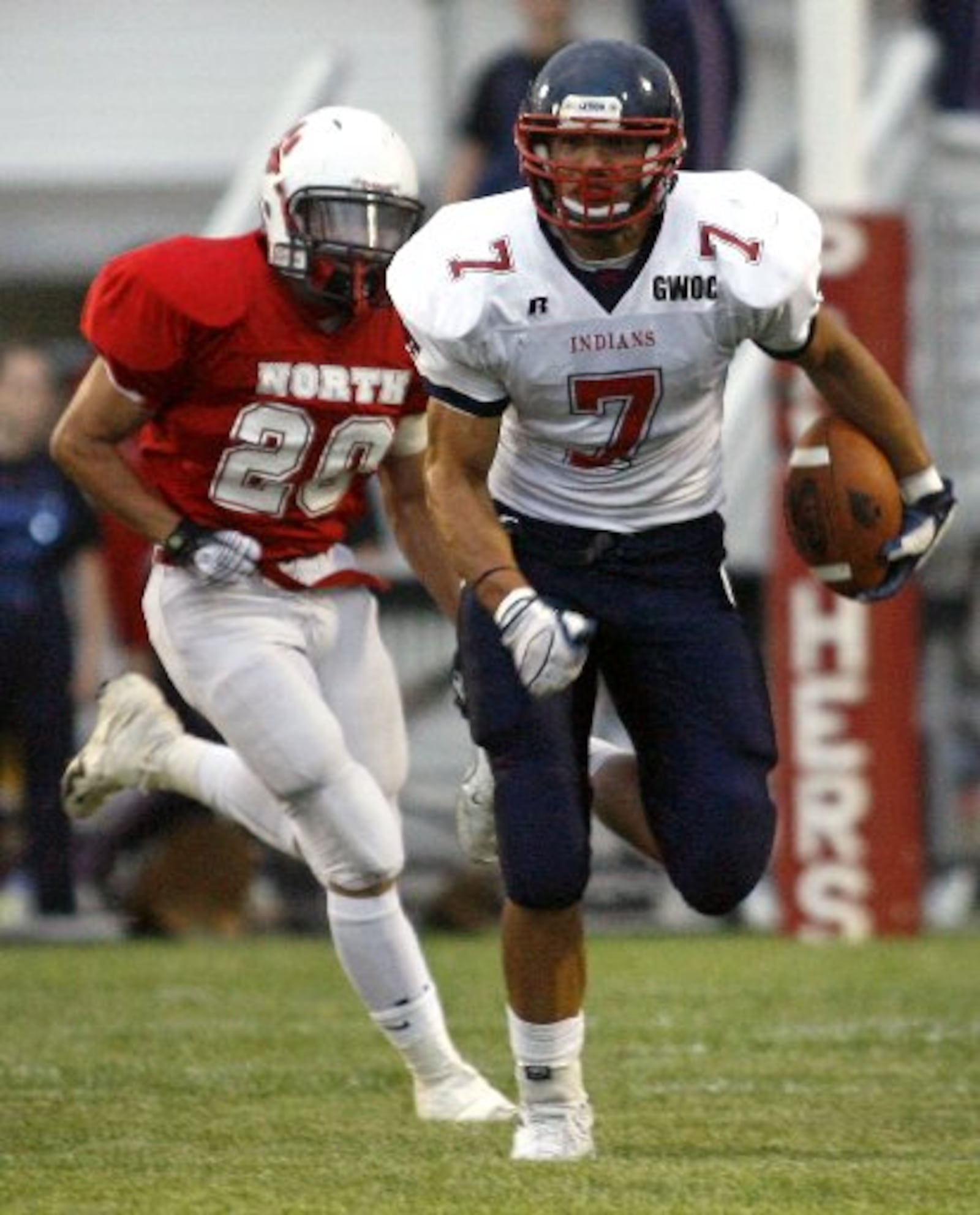 David Rolf (7) of Piqua High School is pursued by John Robinson (20) of Springfield North High School during Friday's game at North. Staff Photo by Barbara J. Perenic