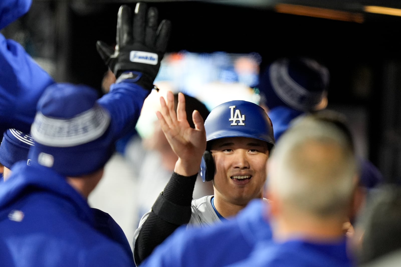 Los Angeles Dodgers' Shohei Ohtani celebrates in the dugout after scoring on Mookie Betts two-run home run against the New York Mets during the sixth inning in Game 4 of a baseball NL Championship Series, Thursday, Oct. 17, 2024, in New York. (AP Photo/Frank Franklin II)