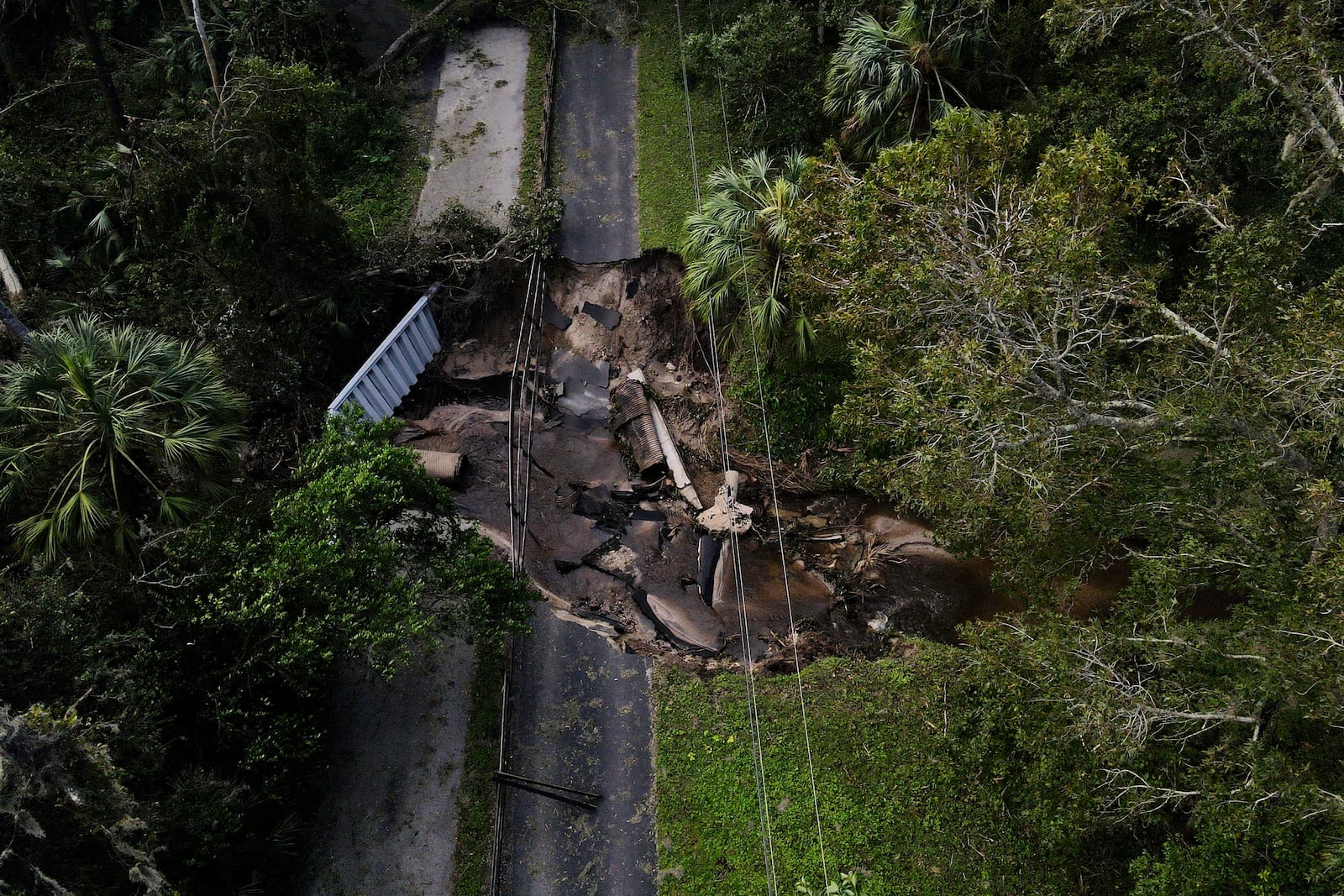 A bridge going over a small creek is seen damaged by Hurricane Milton, Friday, Oct. 11, 2024, in Riverview, Fla. The road is the only access point into a community. (AP Photo/Julio Cortez)