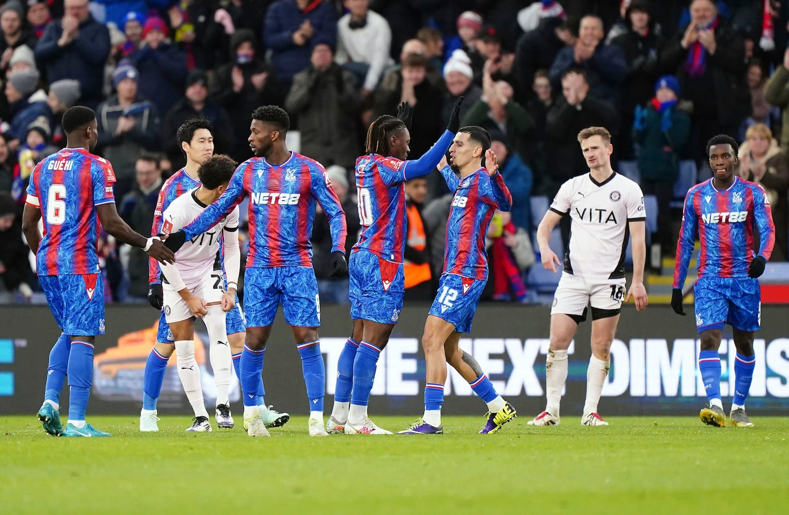 Crystal Palace's Eberechi Eze, center celebrates scoring his side's first goal of the game with teammate Daniel Munoz during the English FA Cup third round soccer match between Crystal Palace and Stockport County at Selhurst Park, London, Sunday, Jan. 12, 2025. (Zac Goodwin/PA via AP)