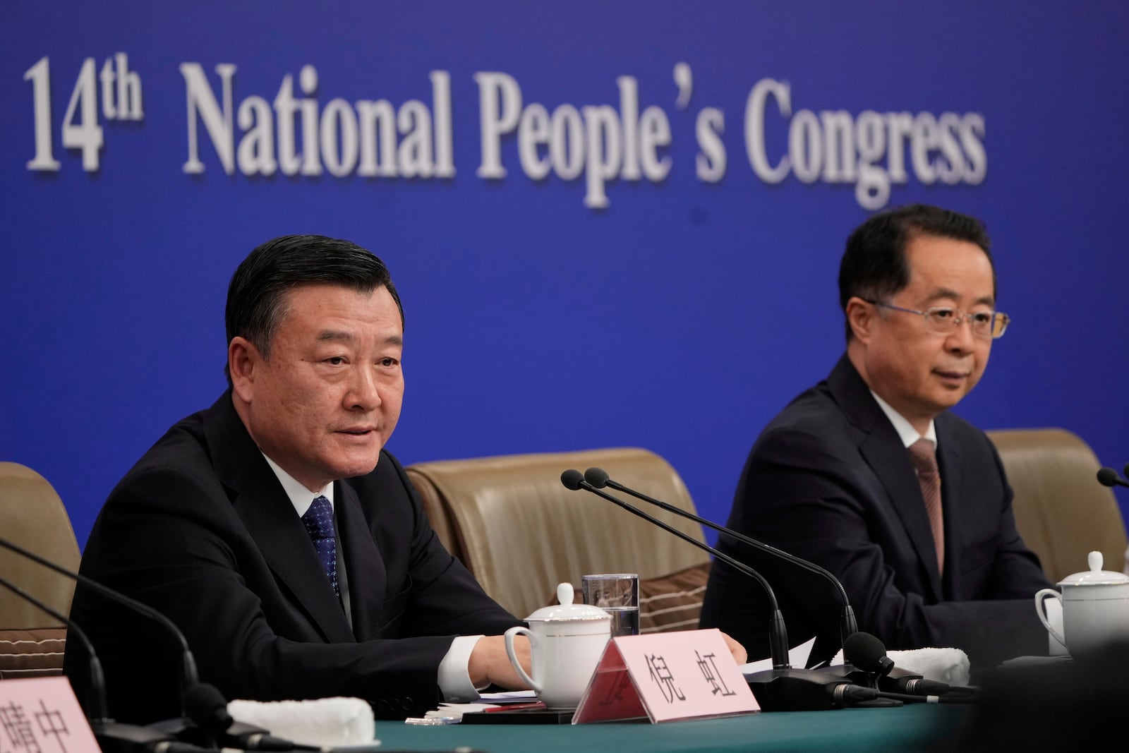 Ni Hong, minister of Housing and Urban-Rural Development, left, and Lu Zhiyuan, minister of Civil Affairs, listen to questions during a press conference for the second session on the sideline of the National People's Congress in Beijing, China, Sunday, March 9, 2025. (AP Photo/Vincent Thian)