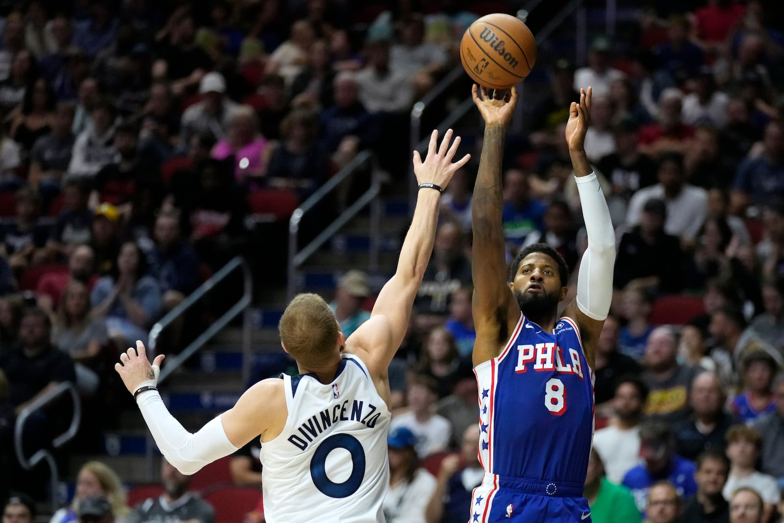 Philadelphia 76ers forward Paul George (8) shoots over Minnesota Timberwolves guard Donte DiVincenzo (0) during the first half of an NBA preseason basketball game, Friday, Oct. 11, 2024, in Des Moines, Iowa. (AP Photo/Charlie Neibergall)