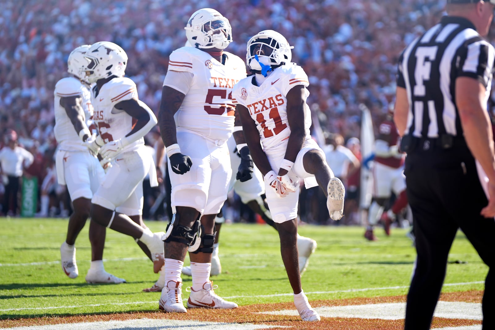 Texas wide receiver Silas Bolden (11) and others celebrate after recovering a teammates fumble in the end zone for a touchdown against Oklahoma in the first half of an NCAA college football game in Dallas, Saturday, Oct. 12, 2024. (AP Photo/Tony Gutierrez)