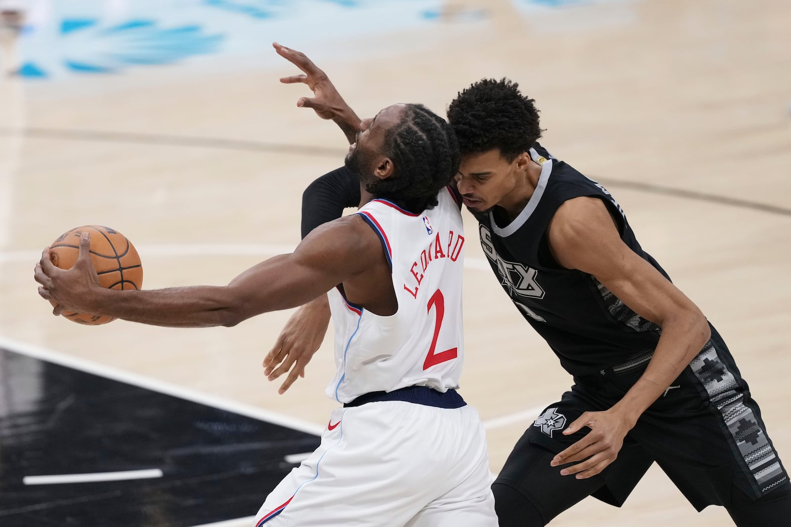 LA Clippers forward Kawhi Leonard (2) drives around San Antonio Spurs center Victor Wembanyama during the first half of an NBA basketball game in San Antonio, Wednesday, Jan. 29, 2025. (AP Photo/Eric Gay)