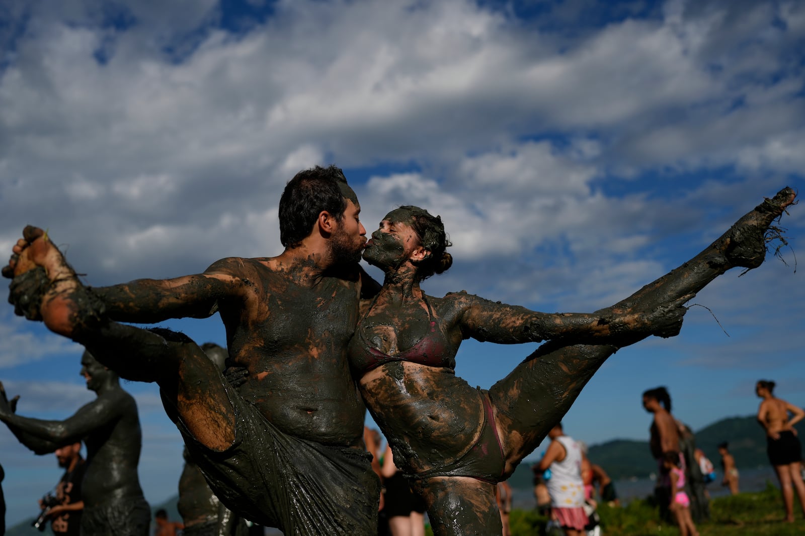 Revelers share a kiss during the traditional Mud Block carnival party in Paraty, Brazil, Saturday, March 1, 2025. (AP Photo/Andre Penner)