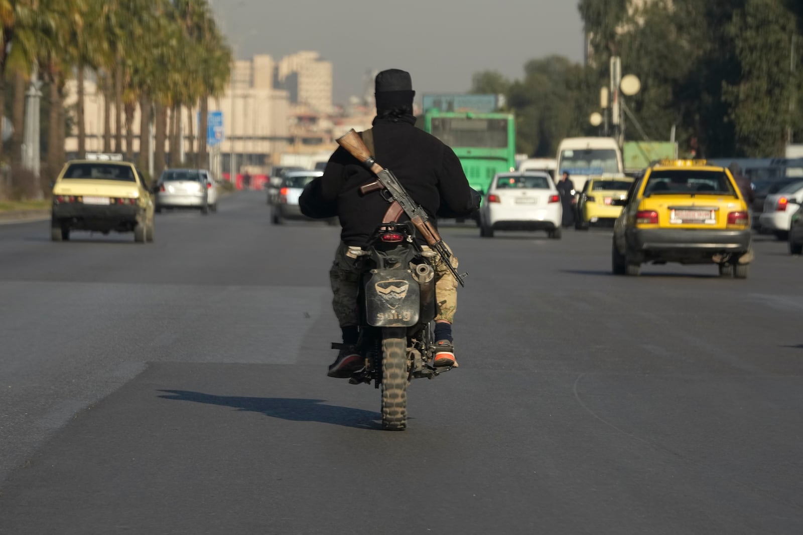 A Syrian fighter from the rebel group drives his motorcycle on highway in Damascus, Syria, Wednesday, Dec. 18, 2024. (AP Photo/Hussein Malla)