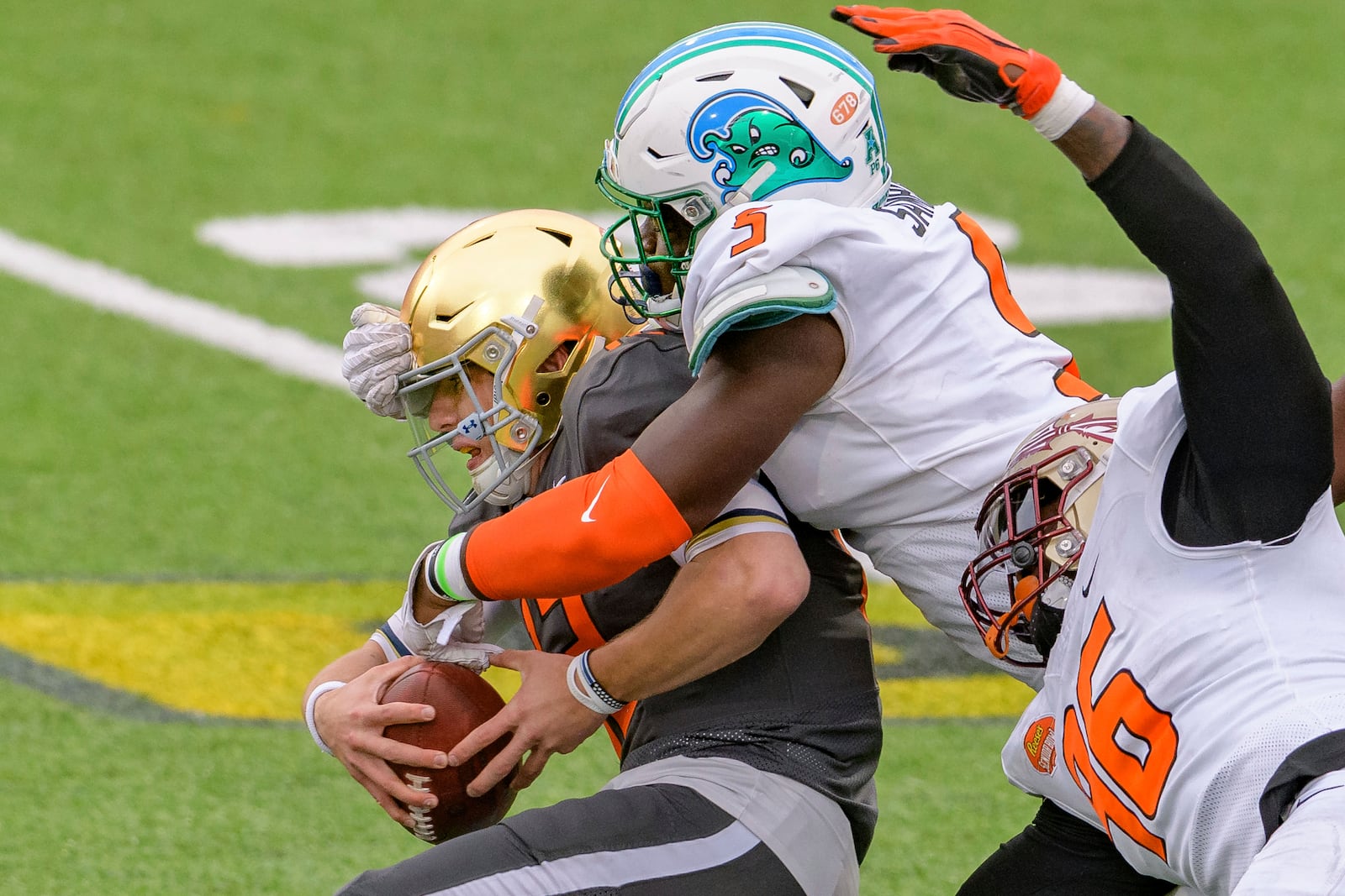 American Team defensive lineman Cameron Sample of Tulane (5) sacks National Team quarterback Ian Book of Notre Dame (12) with the help of American Team Janarius Robinson of Florida State (96) during the NCAA Senior Bowl college football game in Mobile, Ala., Saturday, Jan. 30, 2021. (AP Photo/Matthew Hinton)