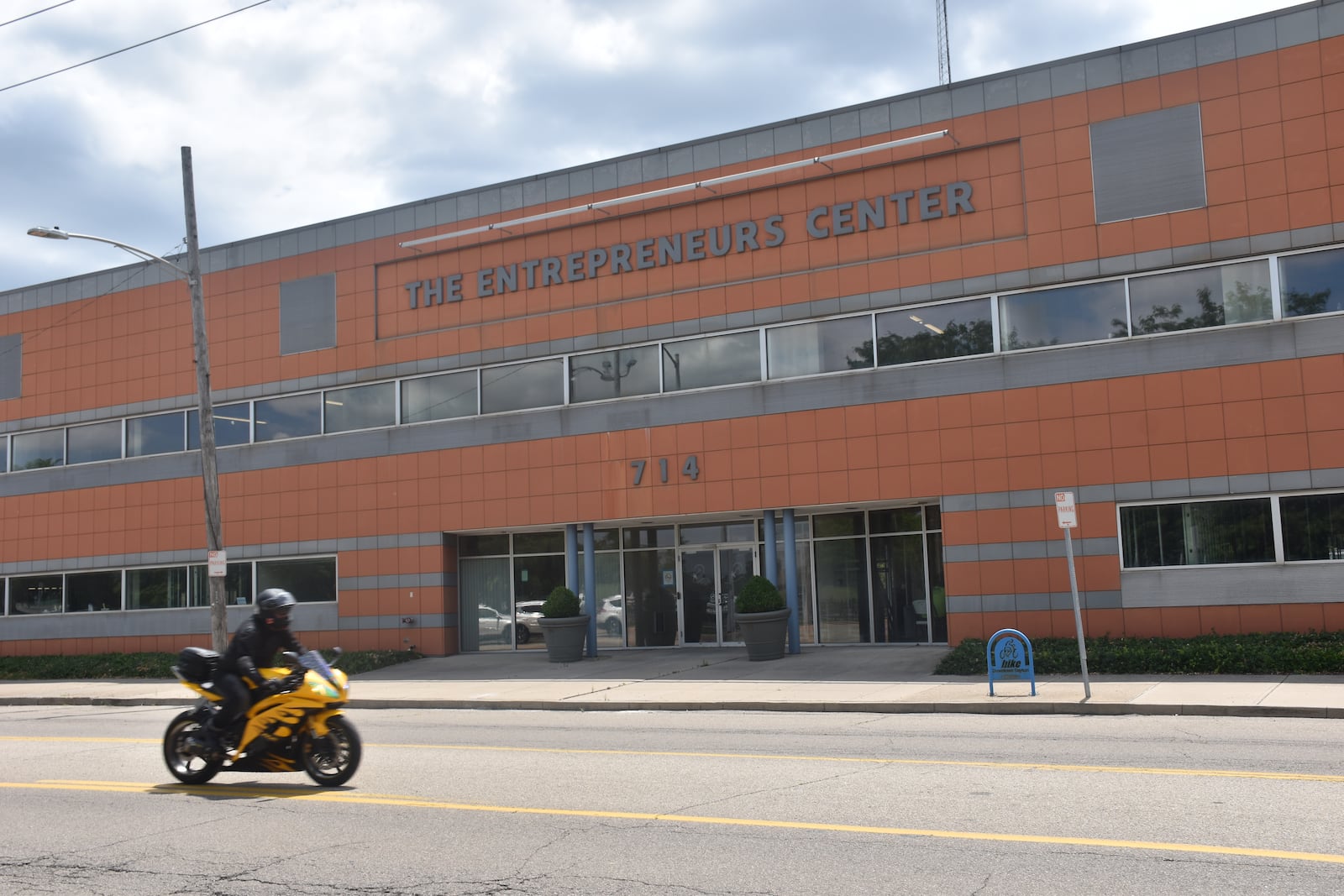 A motorcycle drives by the former Entrepreneurs’ Center at 714 E. Monument Ave. in Dayton's Tech Town area. A company called Diné Development Corp. has purchased the property and expects to employ about 250 people at the facility. CORNELIUS FROLIK / STAFF