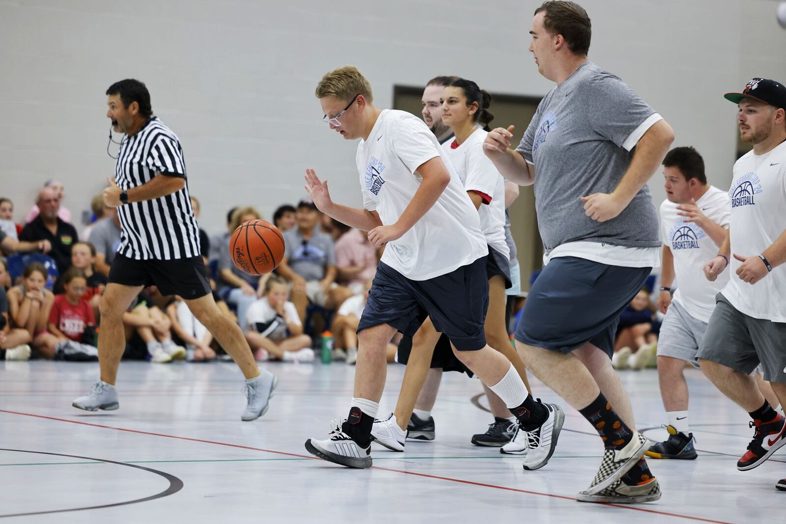 Liam Lovejoy dribbles the ball during "One Special Game" basketball game held for those with special needs during the Luke Kennard basketball camp at Camp Chautauqua Saturday, July 20, 2024. Camp attendees cheered on the players during the event. NICK GRAHAM/STAFF