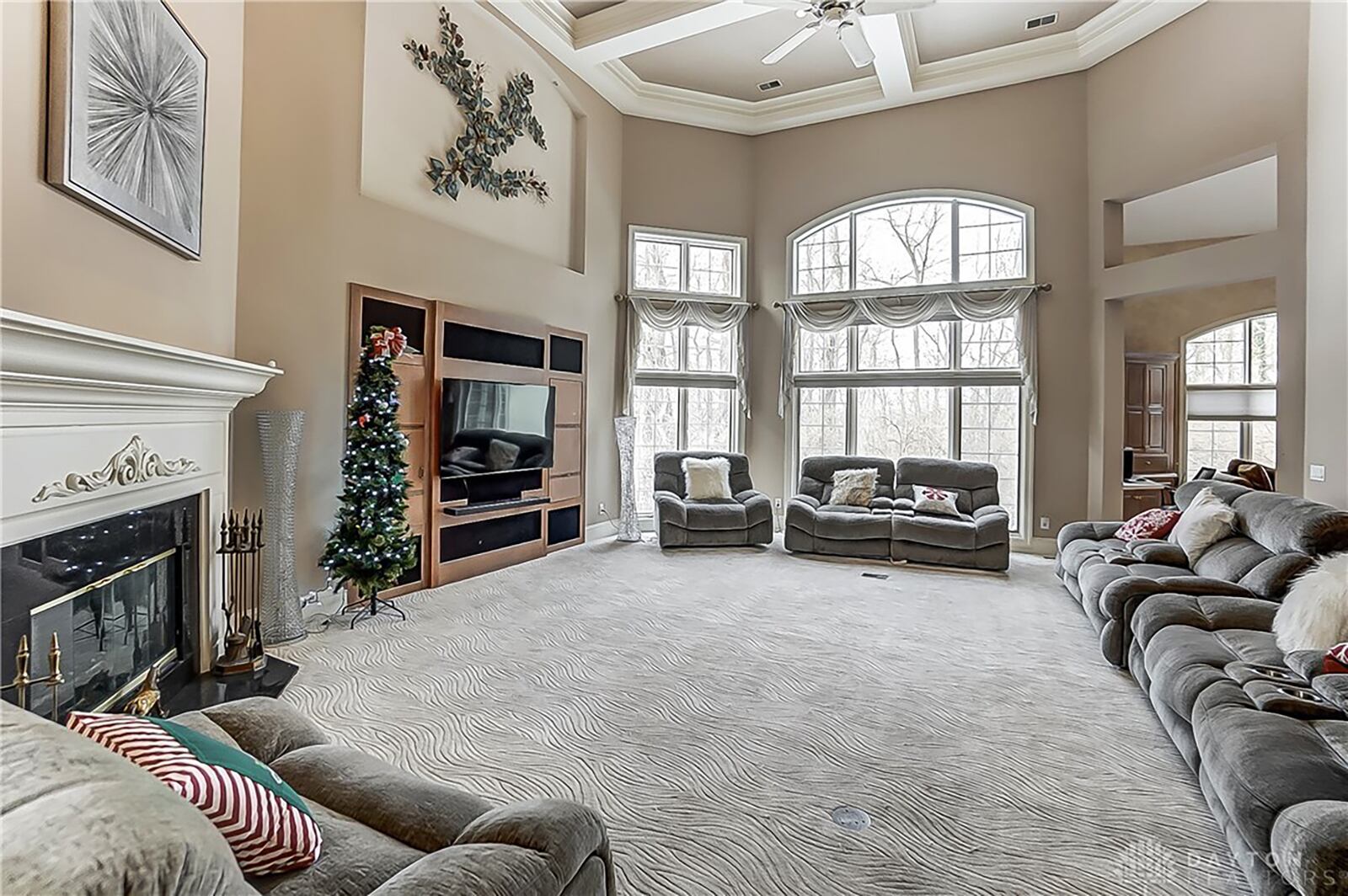 The two story great room has a woodburning fireplace and windows with transoms.