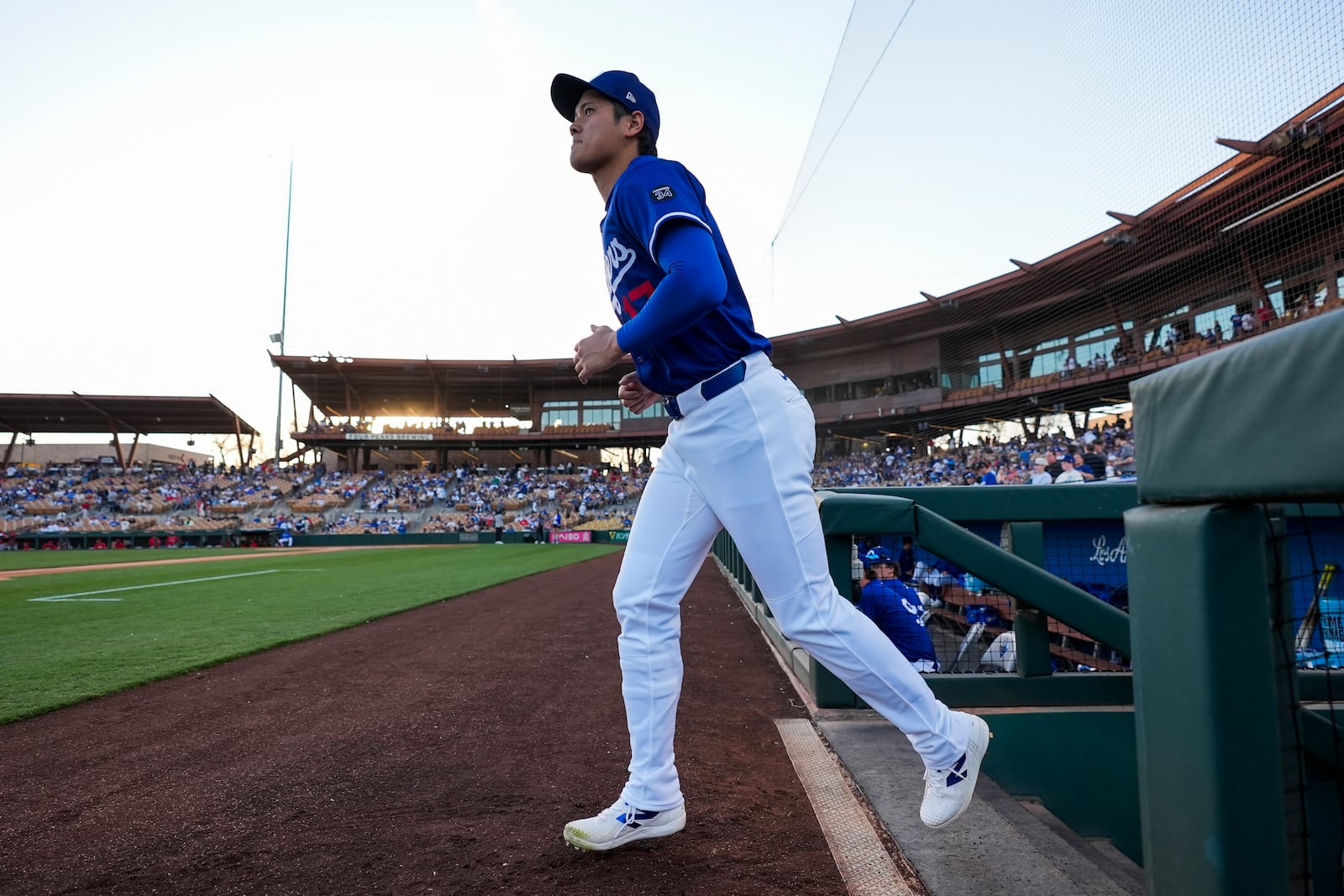 Los Angeles Dodgers designated hitter Shohei Ohtani (17) enters the field before a spring training baseball game against the Los Angeles Angels, Friday, Feb. 28, 2025, in Phoenix. (AP Photo/Ashley Landis)