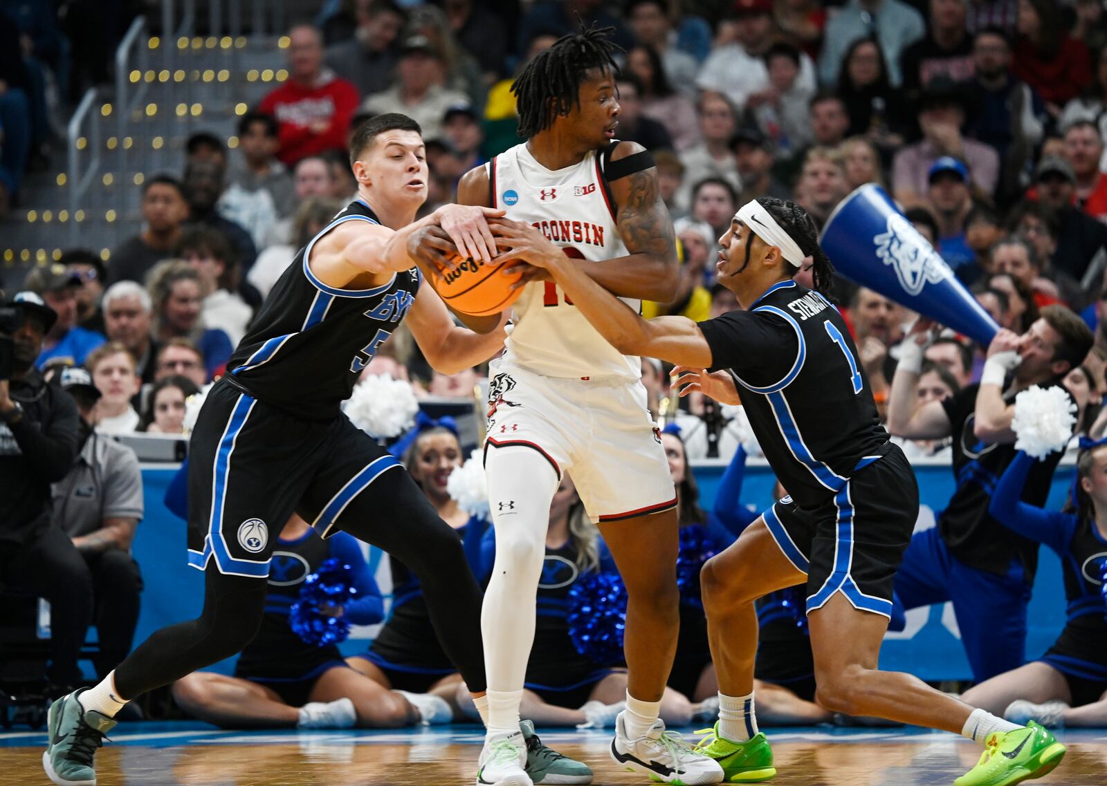 Wisconsin forward Xavier Amosm center, gets trapped with the all by Brigham Young forward Mihailo Boskovic, left, and guard Trey Stewart during the first half in the second round of the NCAA college basketball tournament, Saturday, March 22, 2025, in Denver. (AP Photo/John Leyba)