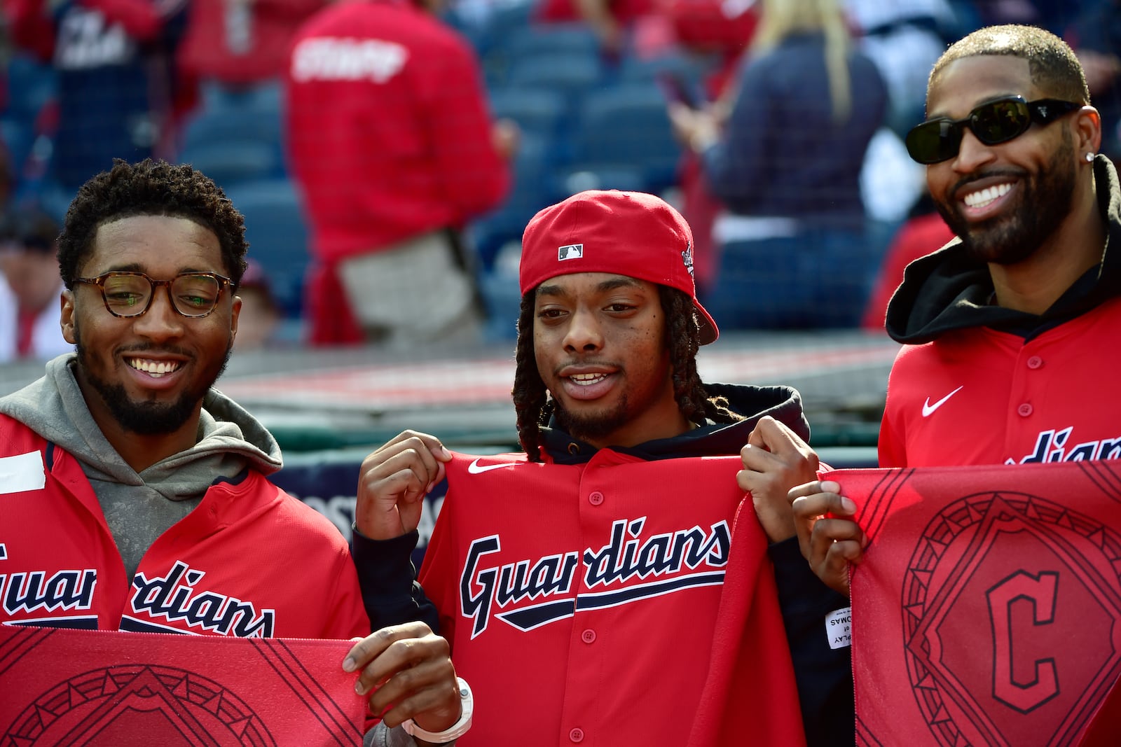 Cleveland Cavaliers players, from left, Donovan Mitchell, Darius Garland and Tristan Thompson pose before Game 5 in baseball's American League Division Series between the Detroit Tigers and the Cleveland Guardians, Saturday, Oct. 12, 2024, in Cleveland. (AP Photo/Phil Long)