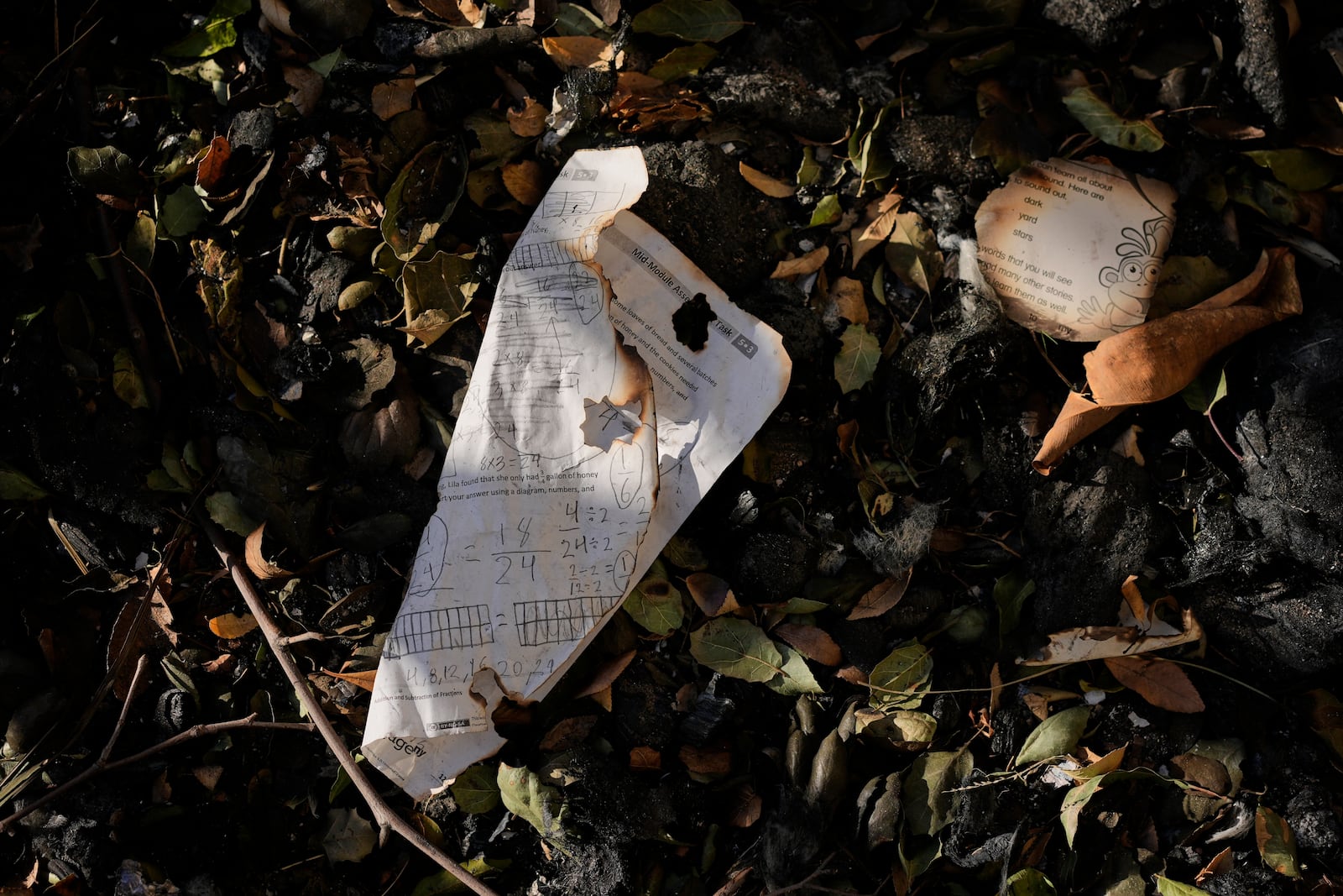 FILE - Burnt school worksheets are seen on the ground outside of an elementary school destroyed by the Eaton Fire, Thursday, Jan. 16, 2025, in Altadena, Calif. (AP Photo/Carolyn Kaster, File)