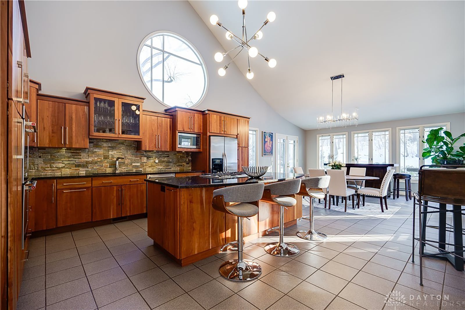 The kitchen has custom cherry cabinets, gourmet appliances including wall ovens and gas cooktop and vaulted ceiling.