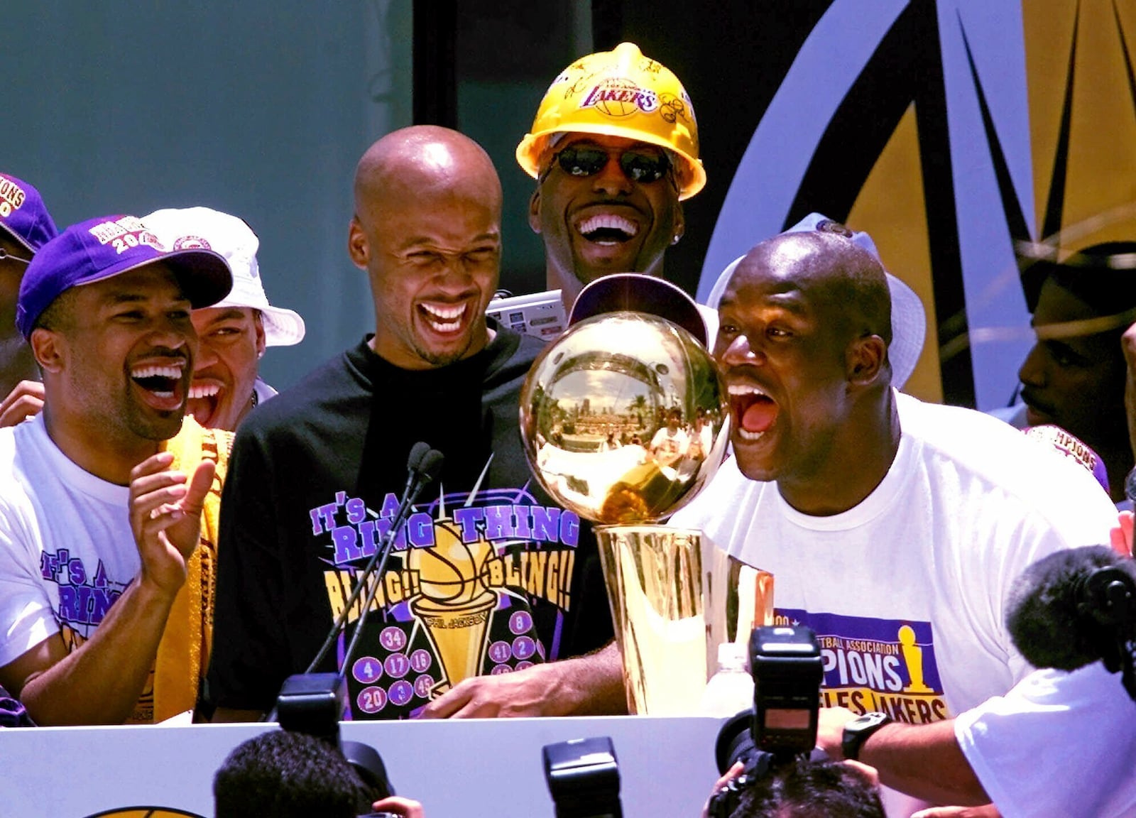 FILE - Los Angeles Lakers' Shaquille O'Neal, right, yells to the crowd as he stands behind the NBA Championship trophy as the Lakers and thousands of their fans celebrate their NBA Championship in downtown Los Angeles, Wednesday, June 21, 2000. (AP Photo/Kevork Djansezian, File)