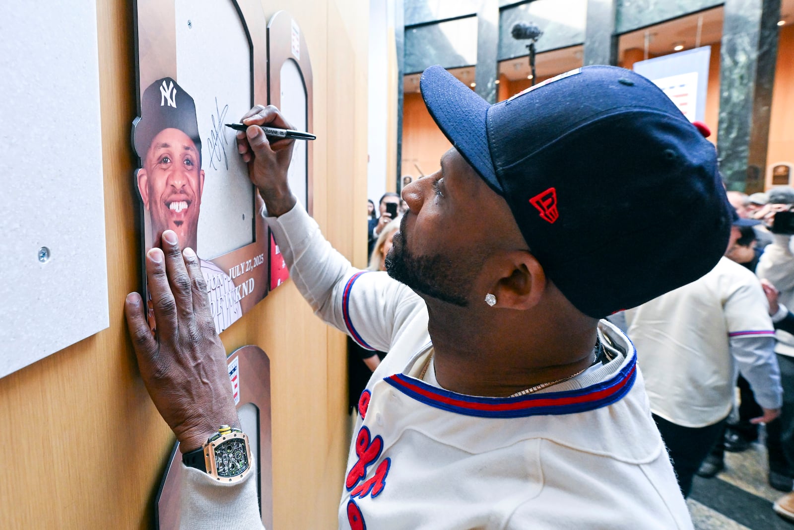 Newly-elected Baseball Hall of Fame member CC Sabathia signs the backer board where his plaque will hang during a news conference Thursday, Jan. 23, 2025, in Cooperstown, N.Y. (AP Photo/Hans Pennink)