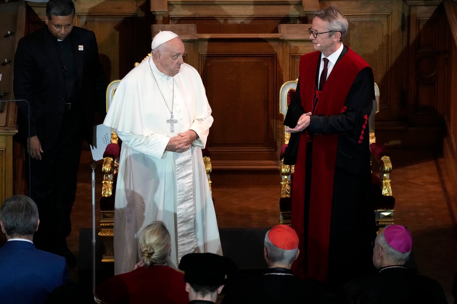 Pope Francis, left, is welcomed by Rector Luc Sels as he arrives for a meeting with the professors in the Promotiezaal of the Catholic University of Leuven, Belgium, Friday, Sept. 27, 2024. (AP Photo/Andrew Medichini)