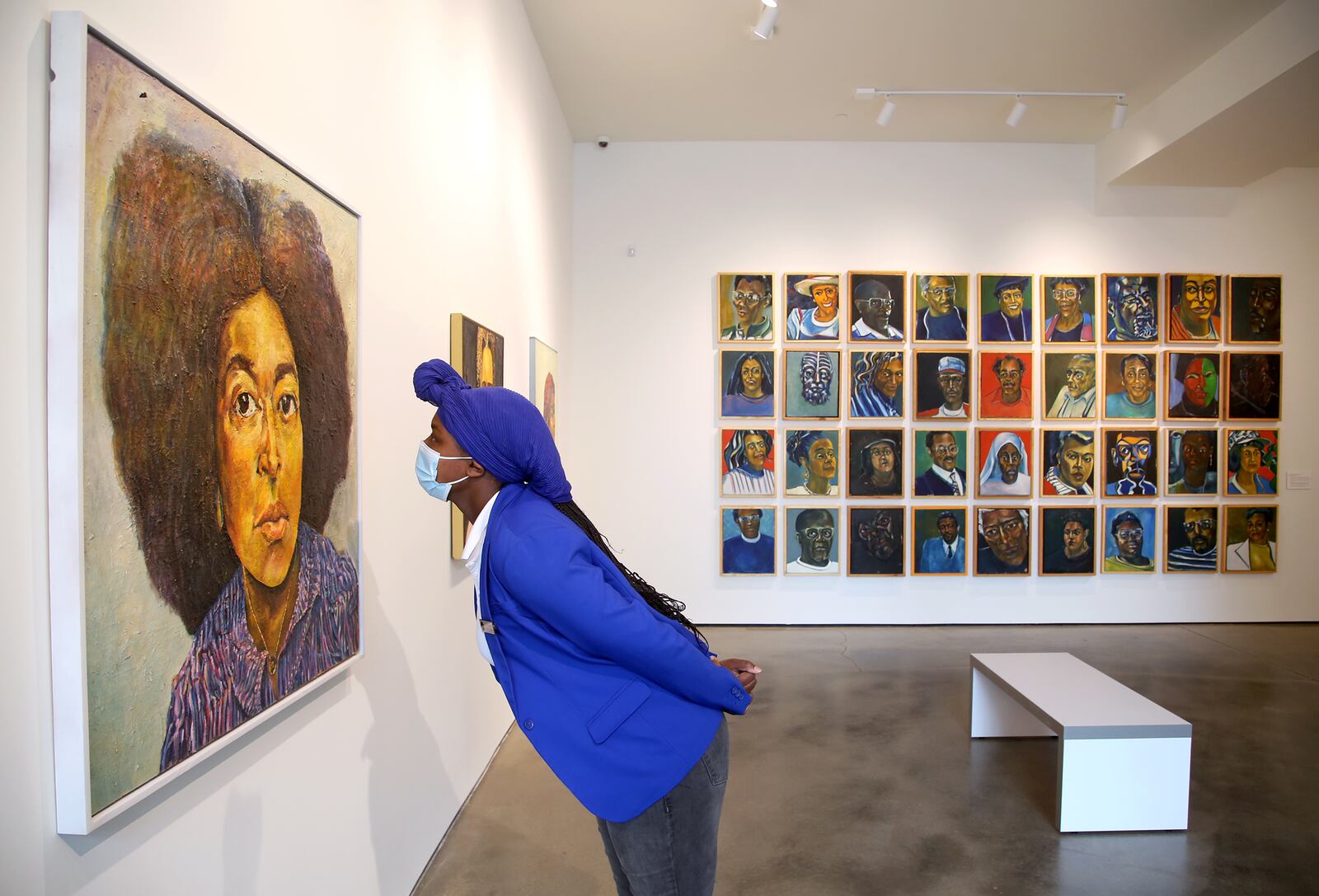 Cydnie King, executive assistant, at the Contemporary Dayton looks at a painting in an exhibition of the work of Curtis Barnes, Sr. The Co has opened in its new home at the Dayton Arcade. The Co has nearly doubled in size to 6,224 square feet at the Dayton Arcade, with five galleries incorporated into the new space. LISA POWELL / STAFF