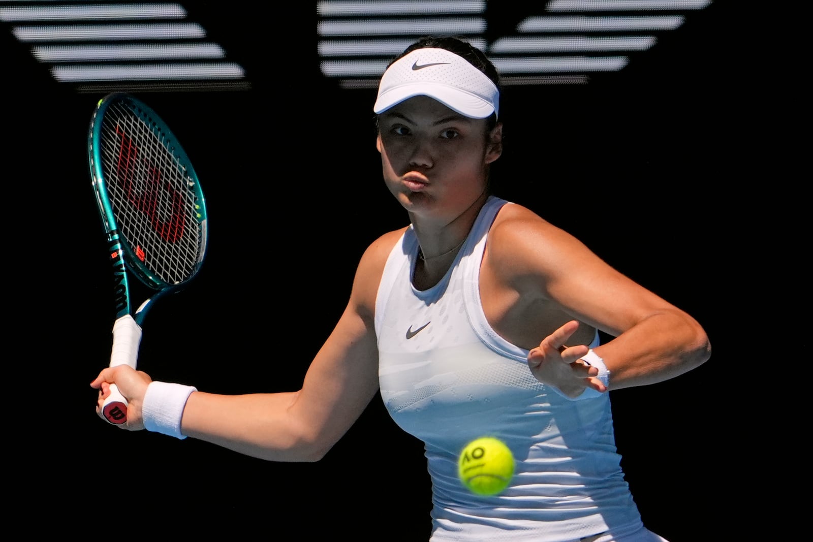 Emma Raducanu of Britain plays a forehand return to Iga Swiatek of Poland during their third round match at the Australian Open tennis championship in Melbourne, Australia, Saturday, Jan. 18, 2025. (AP Photo/Asanka Brendon Ratnayake)