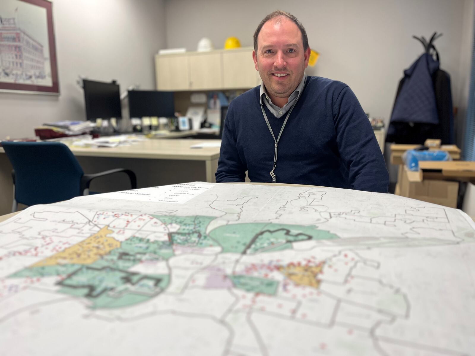 Steve Gondol, Dayton's deputy director of planning, neighborhoods and development, in front of a map in his office showing nuisance and pre-nuisance structures across the city. CORNELIUS FROLIK / STAFF