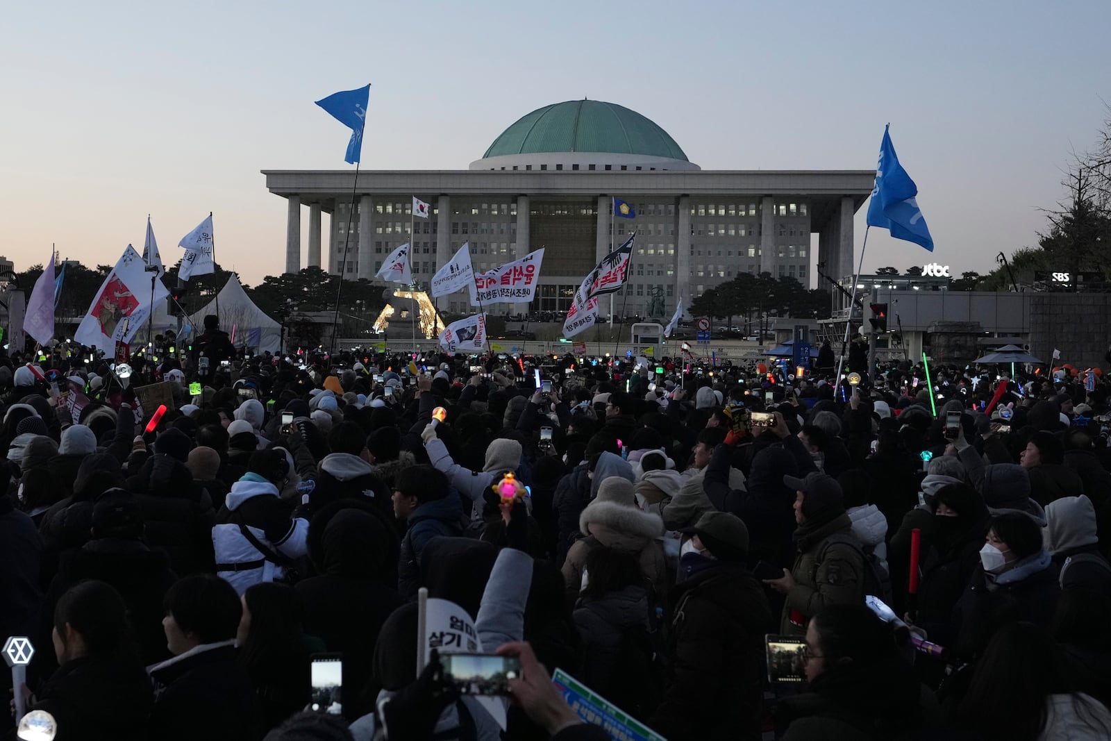 Participants react after hearing the news that South Korea's parliament voted to impeach President Yoon Suk Yeol outside the National Assembly in Seoul, South Korea, Saturday, Dec. 14, 2024. (AP Photo/Lee Jin-man)