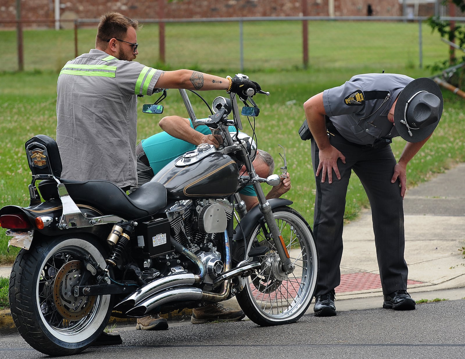 A Ohio State Highway Patrol trooper looks over a motorcycle Thursday, June 13, 2024 removed from a home at 1030 Colorado Drive in Xenia. The Bureau of Alcohol, Tobacco and Firearms and Xenia police were part of the raid on the house. MARSHALL GORBY\STAFF 