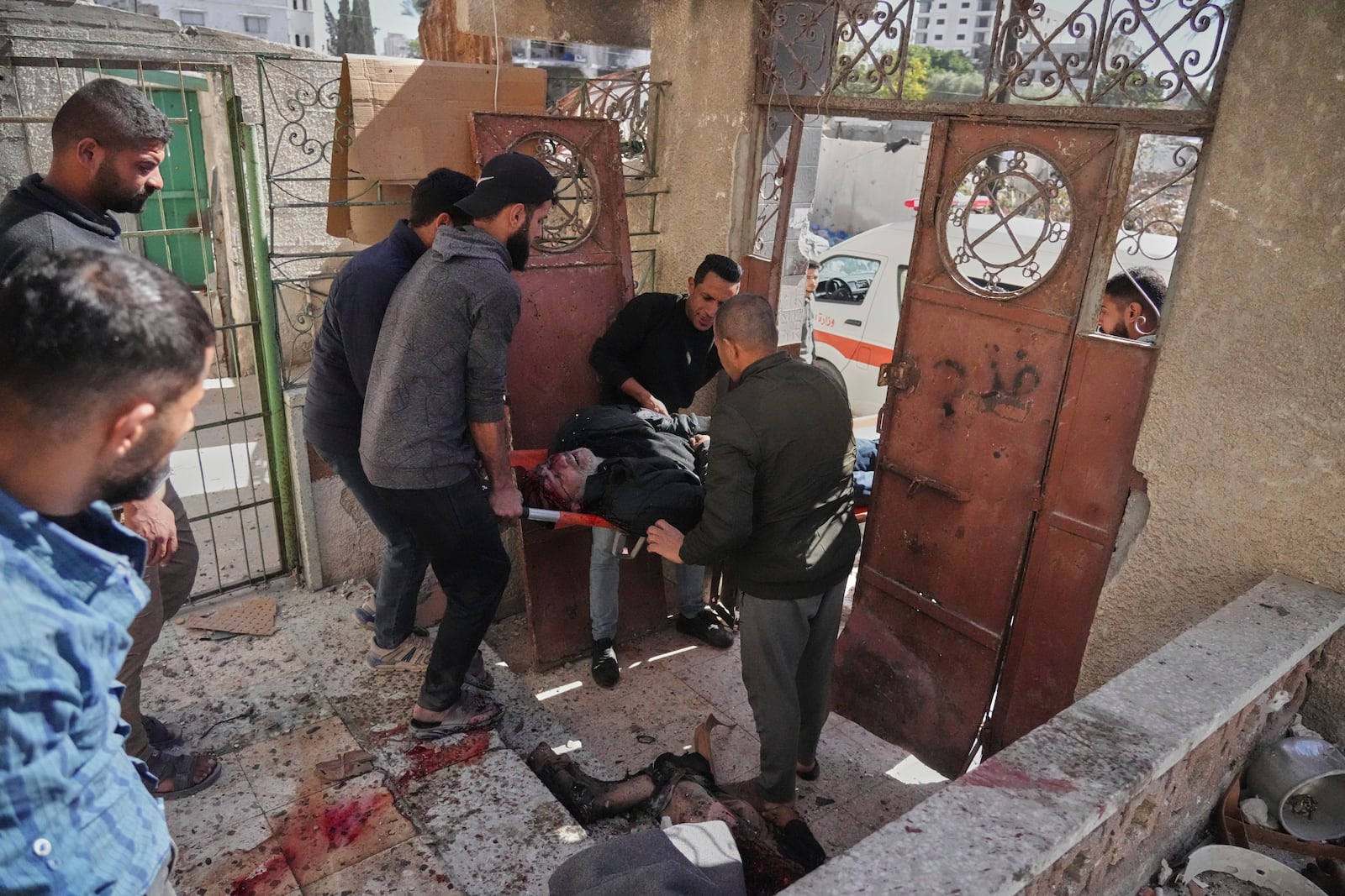 EDS NOTE: GRAPHIC CONTENT - EDS NOTE GRAPHIC CONTENT.-Palestinians evacuate an injured man after his house was hit by an Israeli bombardment in Gaza City, Wednesday, March 19, 2025. (AP Photo/Jehad Alshrafi)