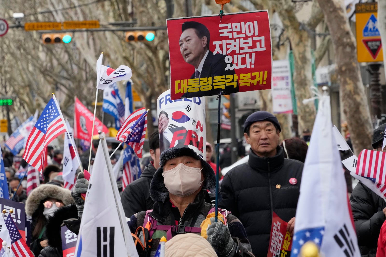 A supporters of impeached South Korean President Yoon Suk Yeol attends a rally to oppose his impeachment near the Constitutional Court in Seoul, South Korea, Tuesday, Feb. 25, 2025. The letters read "President's immediate return." (AP Photo/Ahn Young-joon)