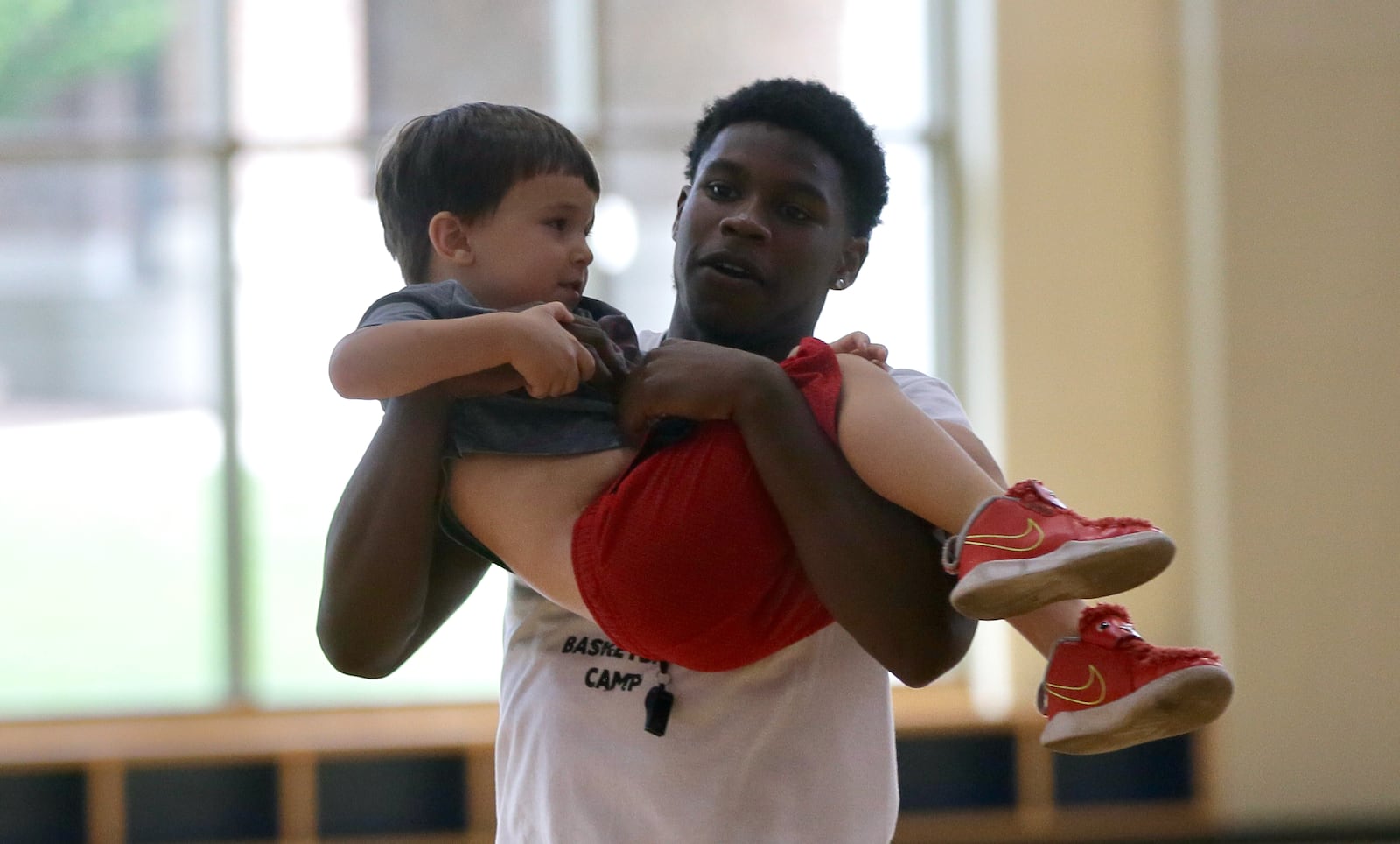 Malachi Smith gives former Dayton student manager and graduate assistant Dan Helm's son a ride after the Smith Camp on Saturday, July 16, 2023, at the UD Rec Plex. David Jablonski/Staff