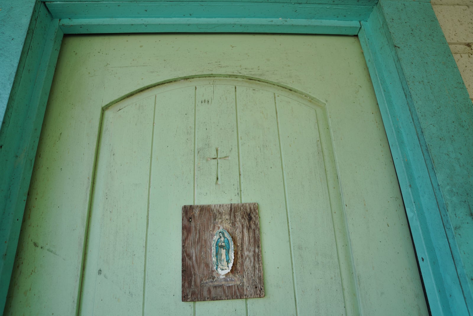 An image of Our Lady of Guadalupe hangs on the door of the late Amada Cardenas’ home, who was one of the first federally licensed peyote dealers, alongside her husband, to harvest and sell the sacramental plant to followers of the Native American Church, in Mirando City, Texas, Monday, March 25, 2024. (AP Photo/Jessie Wardarski)