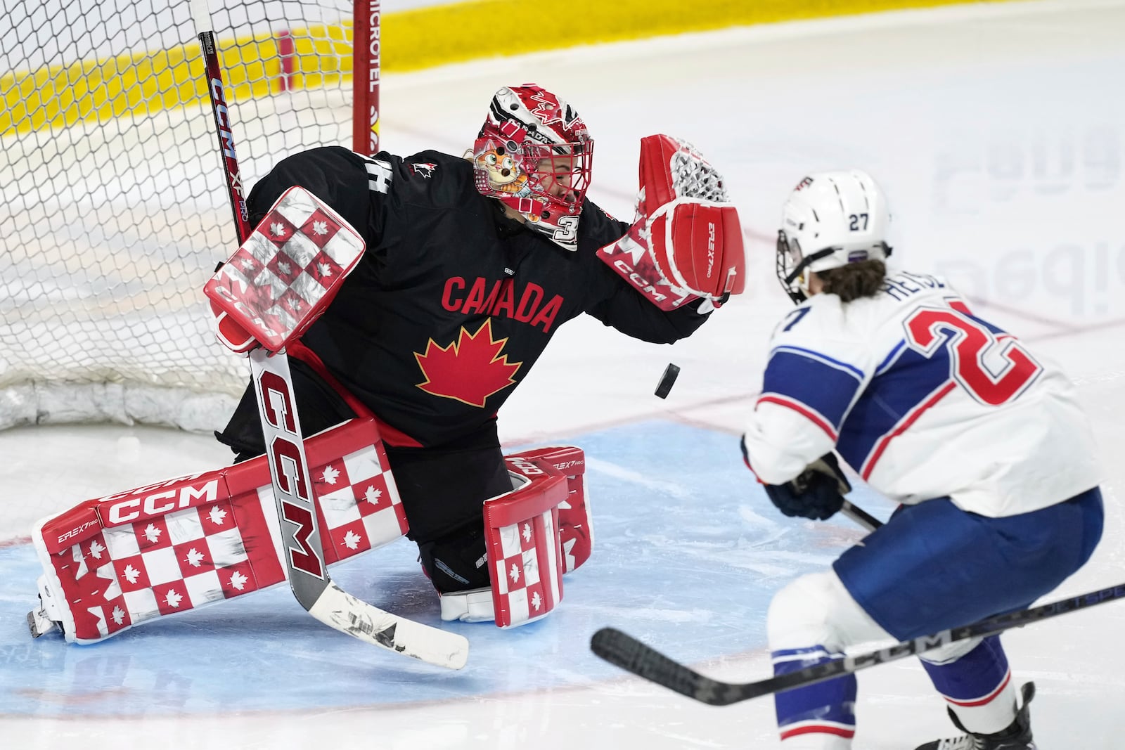 Team Canada goaltender Emerance Maschmeyer, left, makes a save against United States' Taylor Heise, right, during the third period of a Rivalry Series hockey game in Summerside, Prince Edward Island, Canada, Saturday, Feb. 8, 2025. (Darren Calabrese/The Canadian Press via AP)